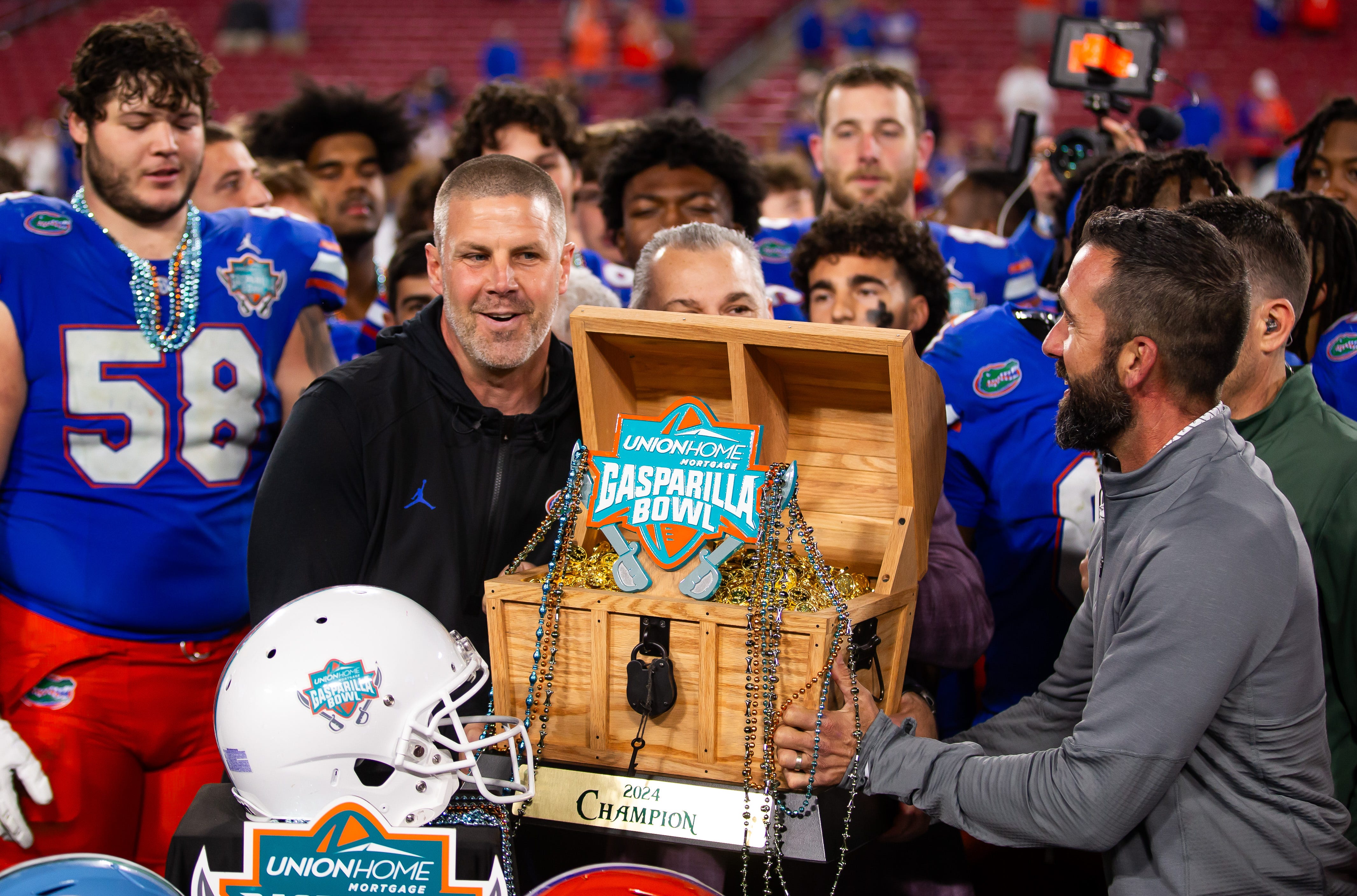 Florida Gators head coach Billy Napier lifts the 2024 Union Home Mortgage Gasparilla Bowl trophy in Raymond James Stadium in Tampa, FL on Friday, December 20, 2024 after defeating Tulane 33-8.