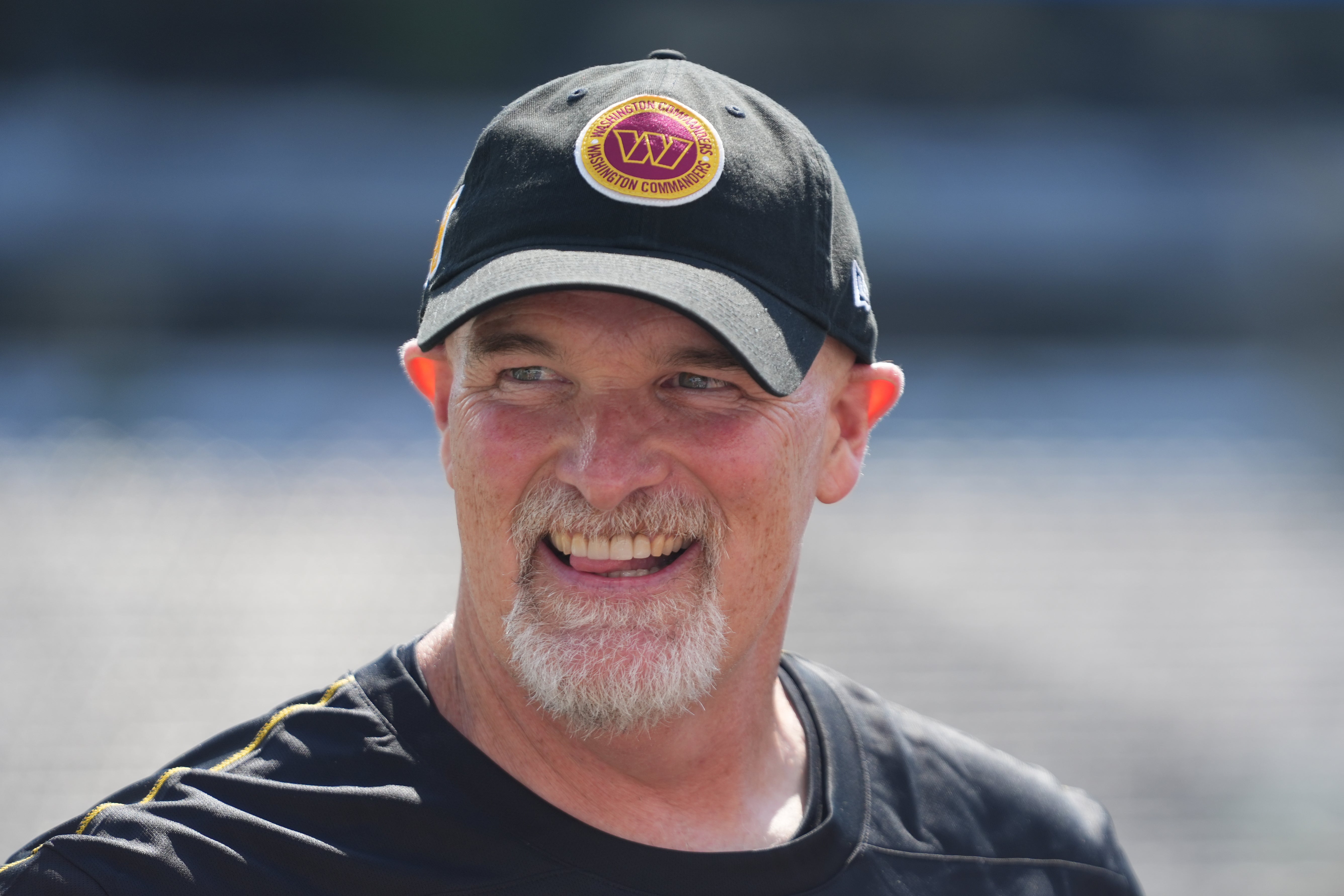 Aug 10, 2024; East Rutherford, New Jersey, USA; Washington Commanders head coach Dan Quinn smiles before the game against the New York Jets at MetLife Stadium.