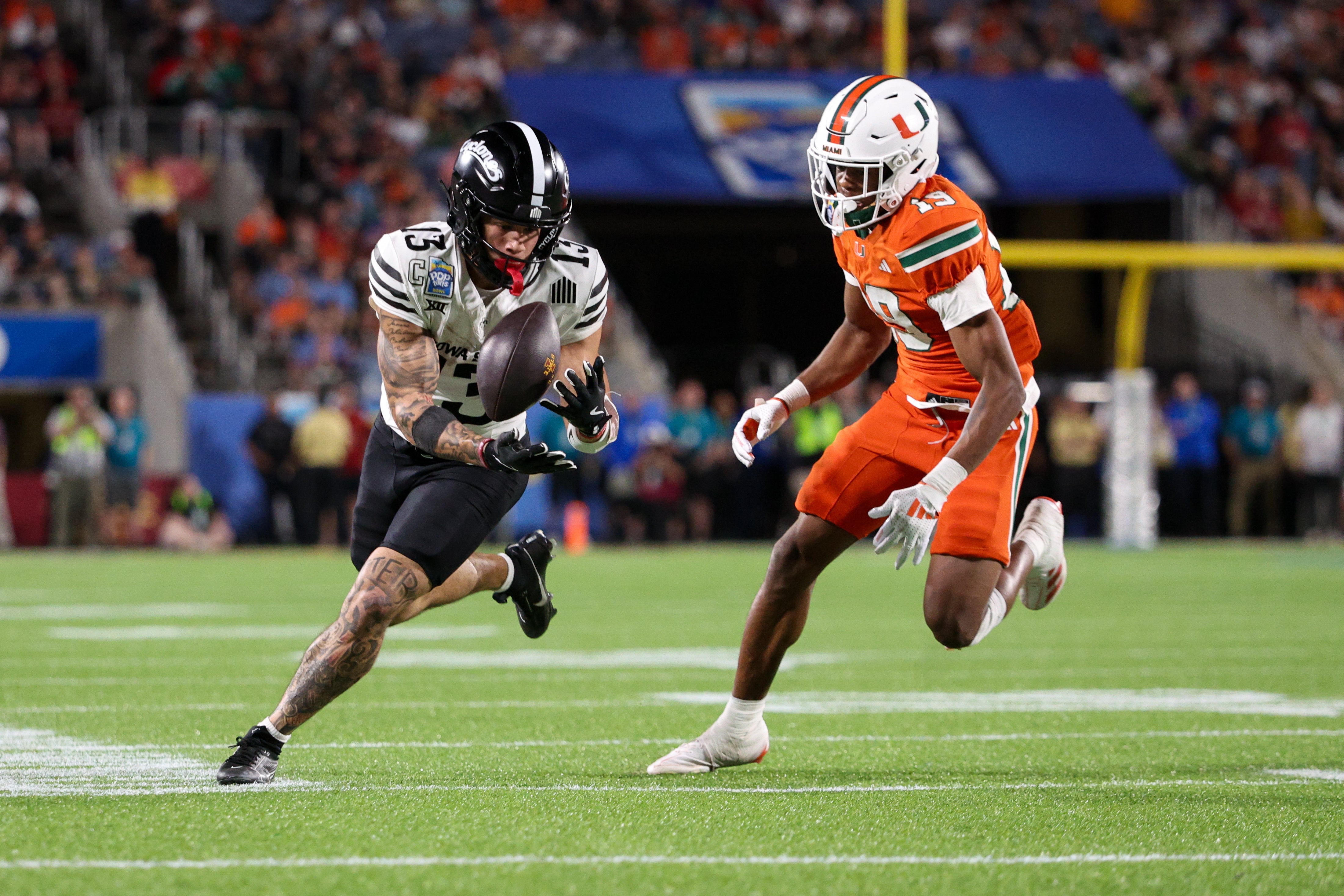 Iowa State Cyclones wide receiver Jaylin Noel (13) receives a pass defended by Miami Hurricanes defensive back D'Yoni Hill (19) in the fourth quarter during the Pop Tarts bowl at Camping World Stadium.