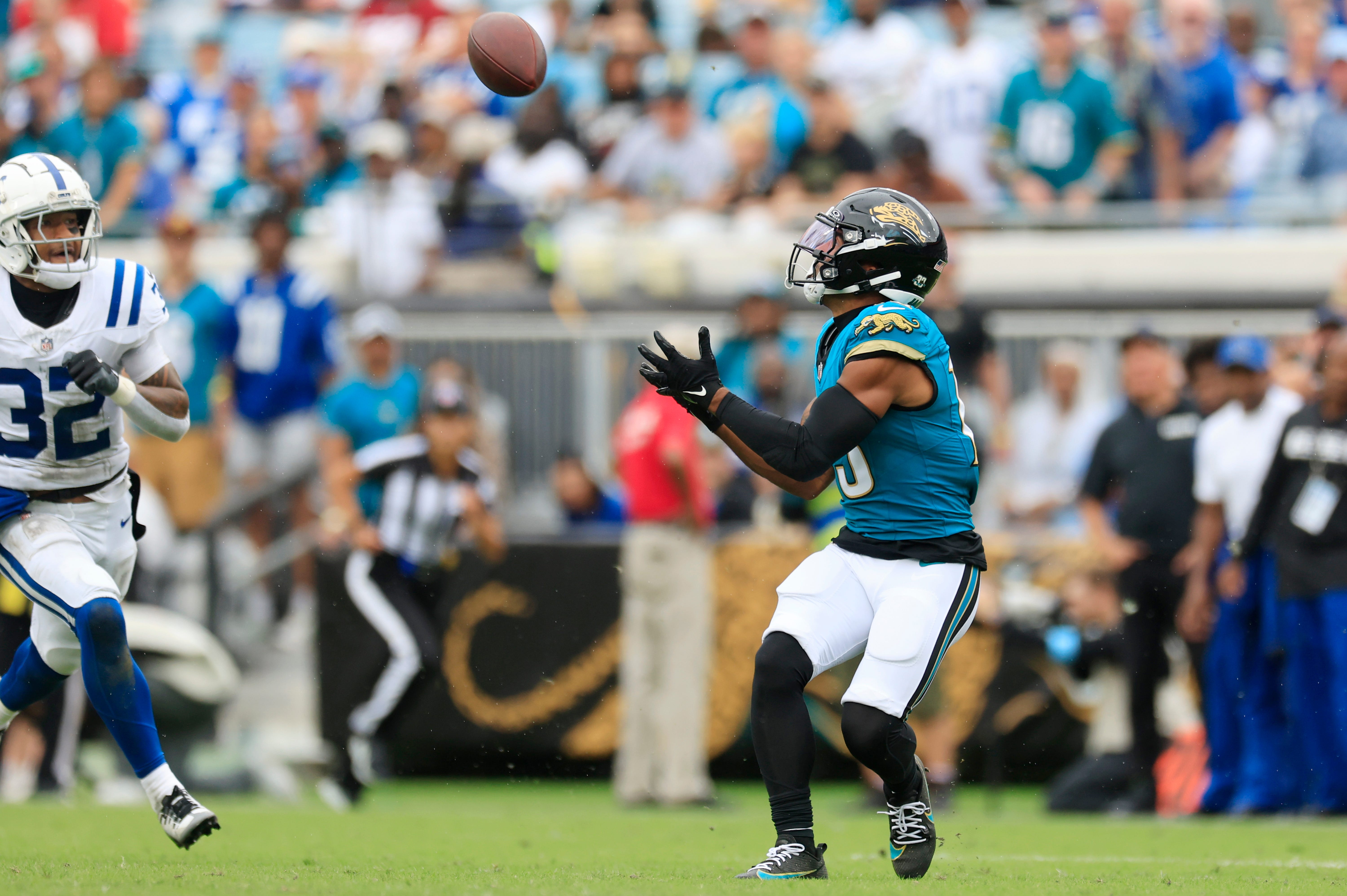 Jaguars wide receiver Christian Kirk (13) hauls in a reception as Colts safety Julian Blackmon (32) looks on.