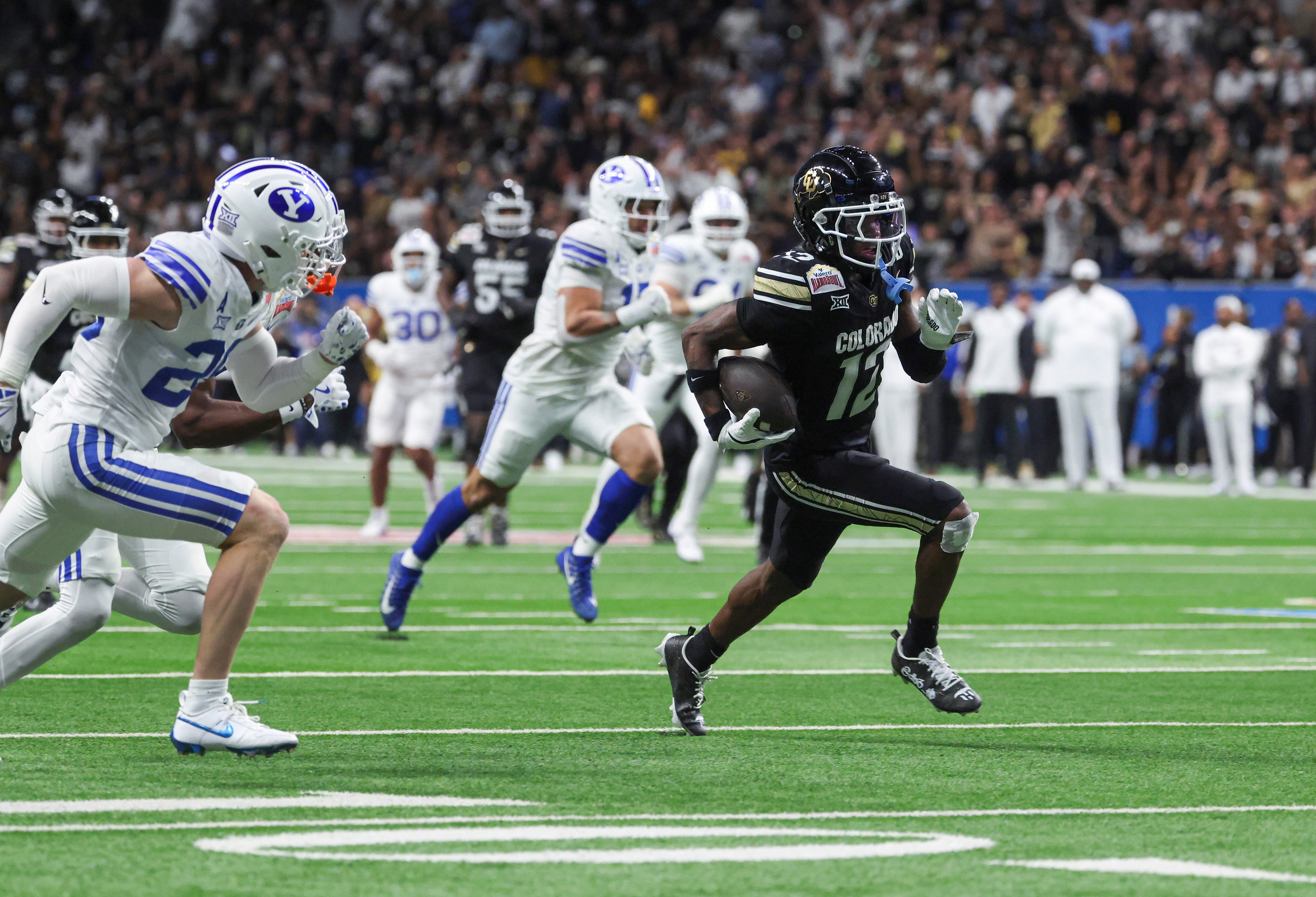 Dec 28, 2024; San Antonio, TX, USA; Colorado Buffaloes wide receiver Travis Hunter (12) runs with the ball and scores a touchdown during the third quarter against the Brigham Young Cougars at Alamodome.