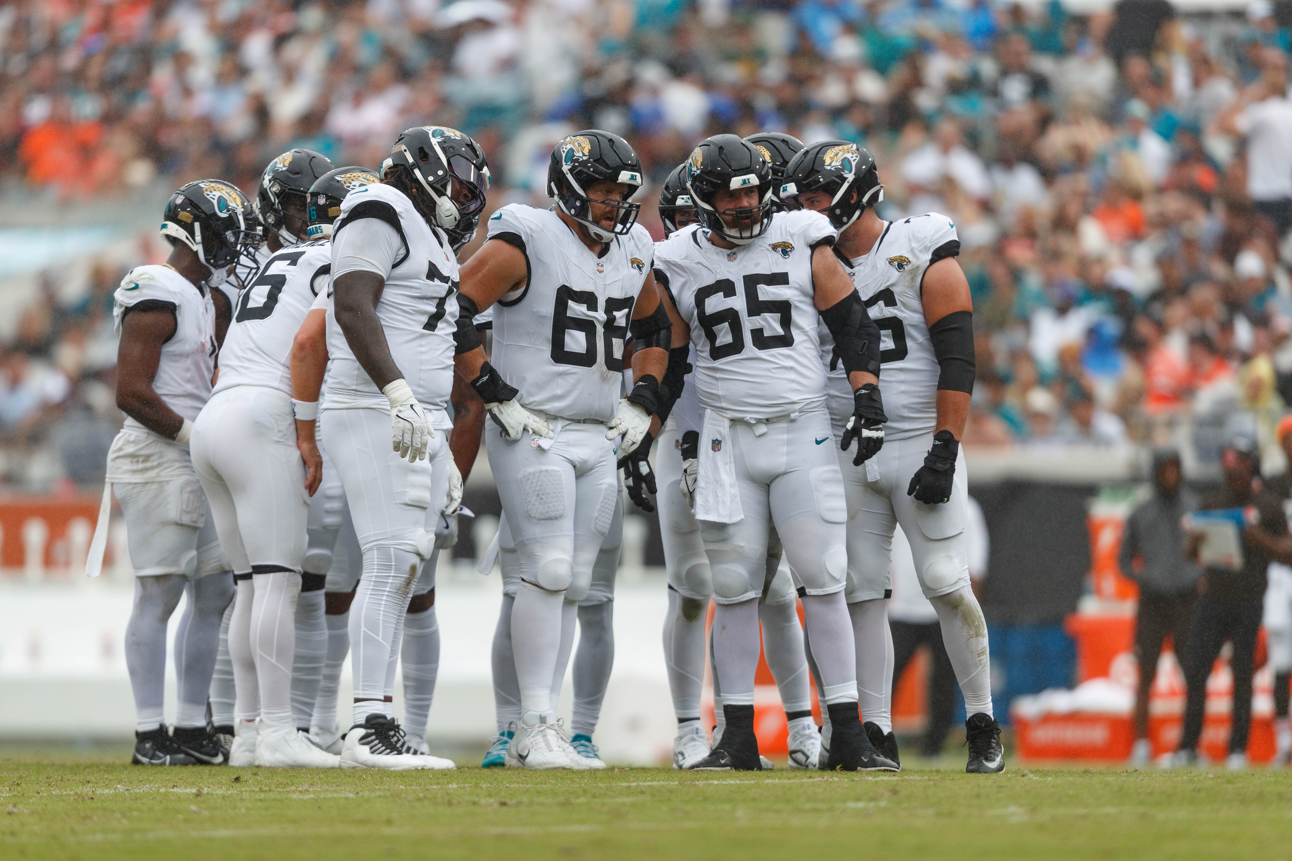Jaguars offensive line Anton Harrison (77), offensive line Brandon Scherff (68), and offensive line Mitch Morse (65) wait to line up for a drive against the Browns.