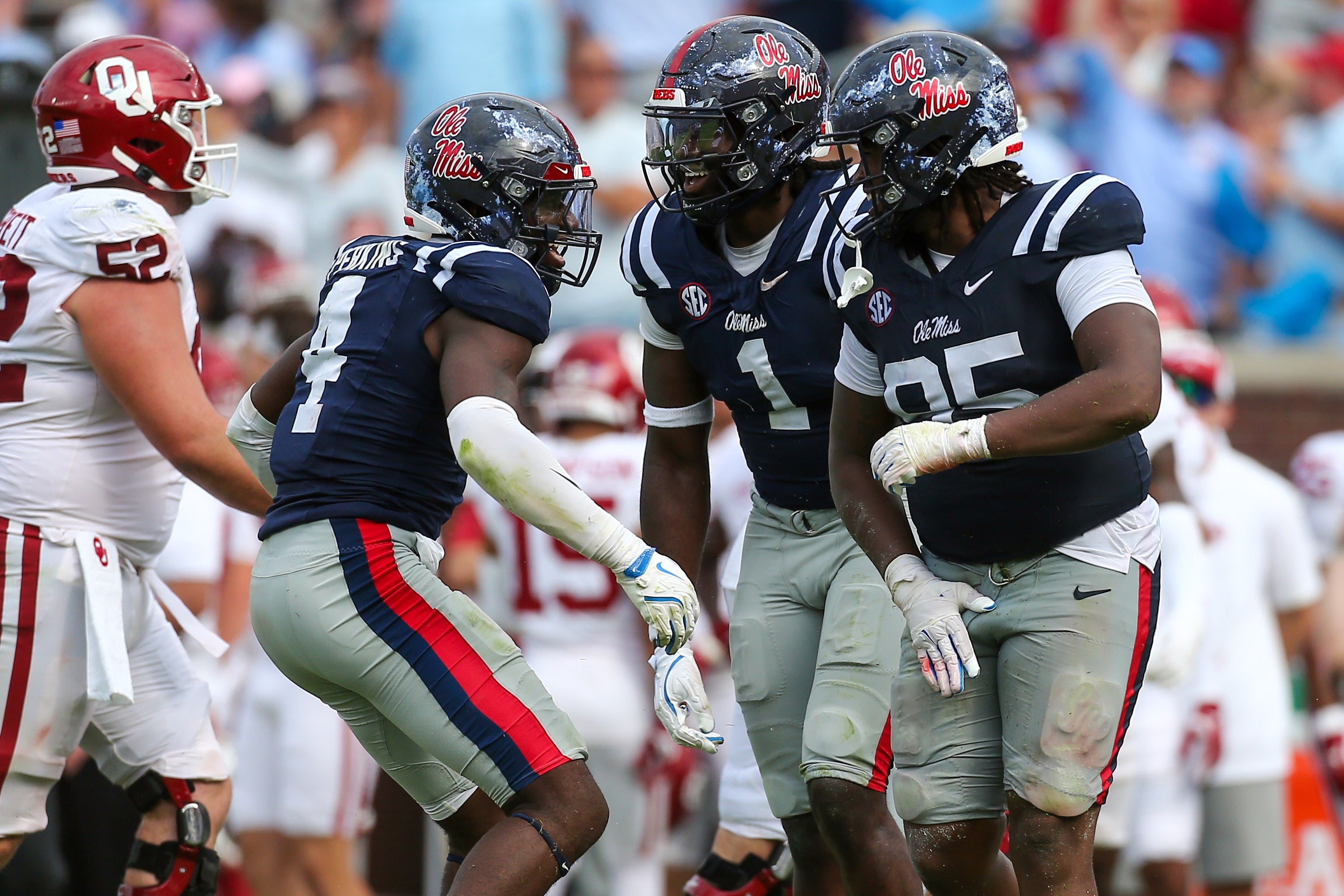 Princely Umanmielen, Suntarine Perkins, and Akelo Stone celebrate a defensive play for Ole Miss