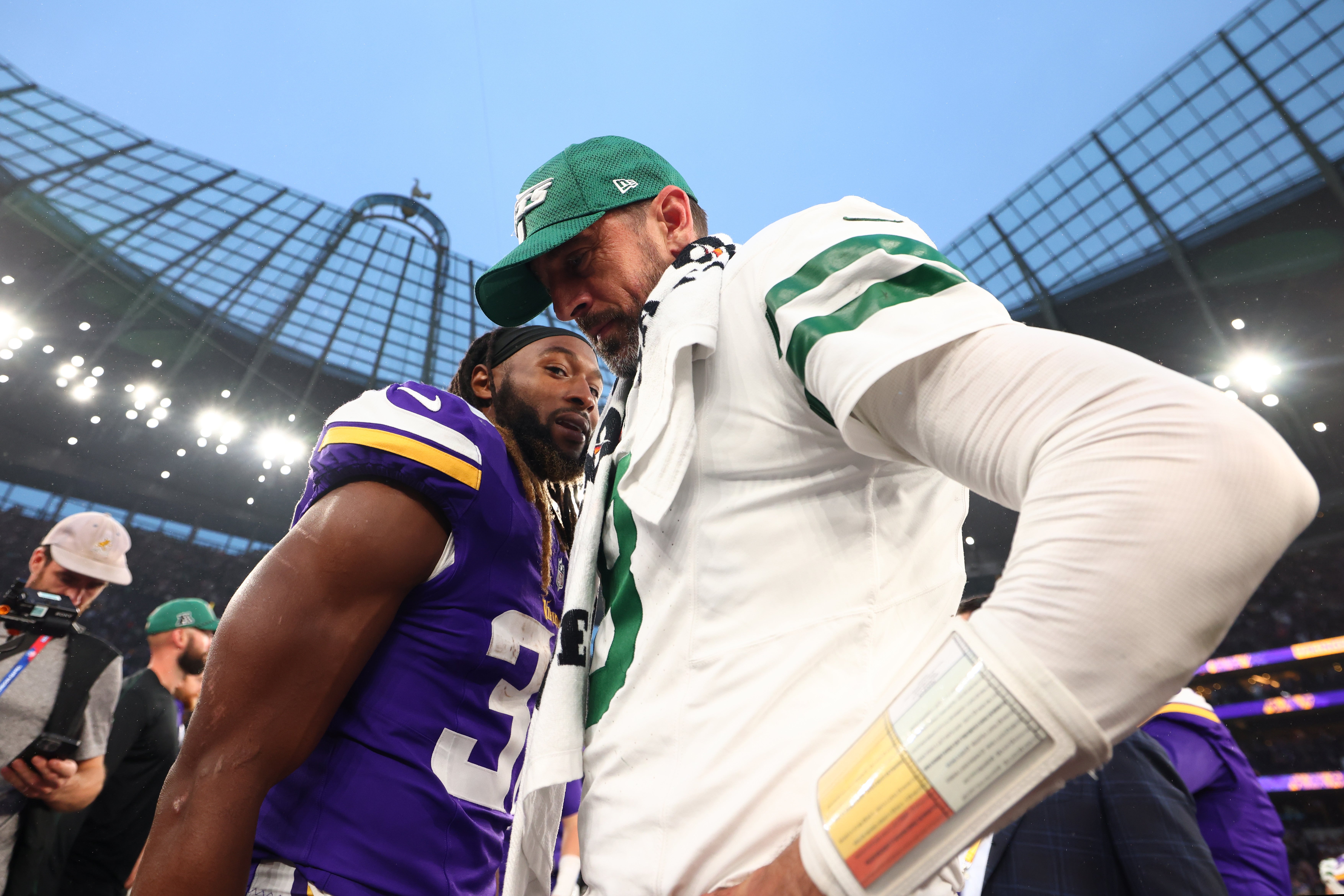 New York Jets quarterback Aaron Rodgers (8) speaks with Minnesota Vikings Running Back Aaron Jones (33) after the 17-23 defeat at Tottenham Hotspur Stadium. 