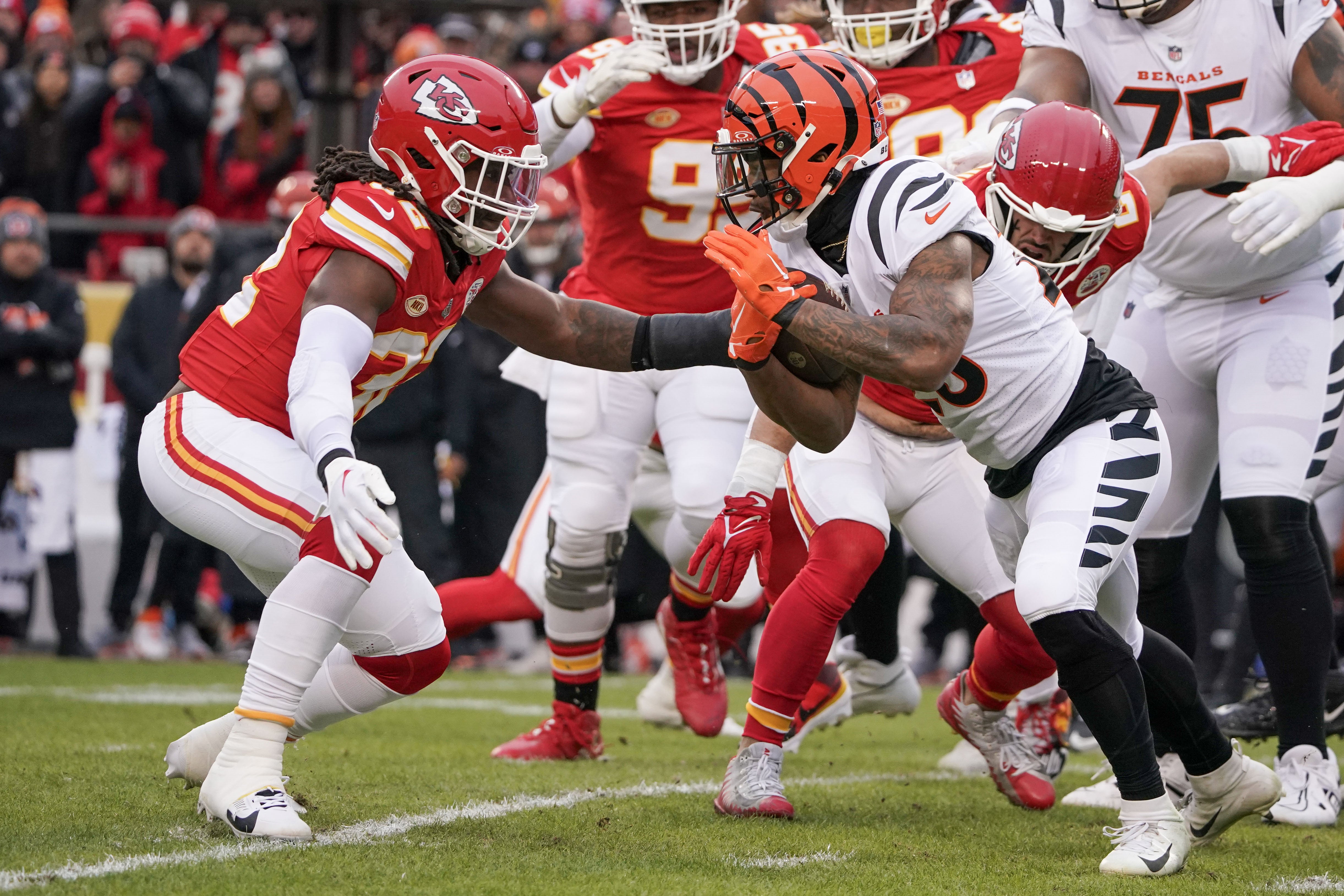 Bengals running back Joe Mixon (28) runs the ball as Chiefs linebacker Nick Bolton (32) defends
