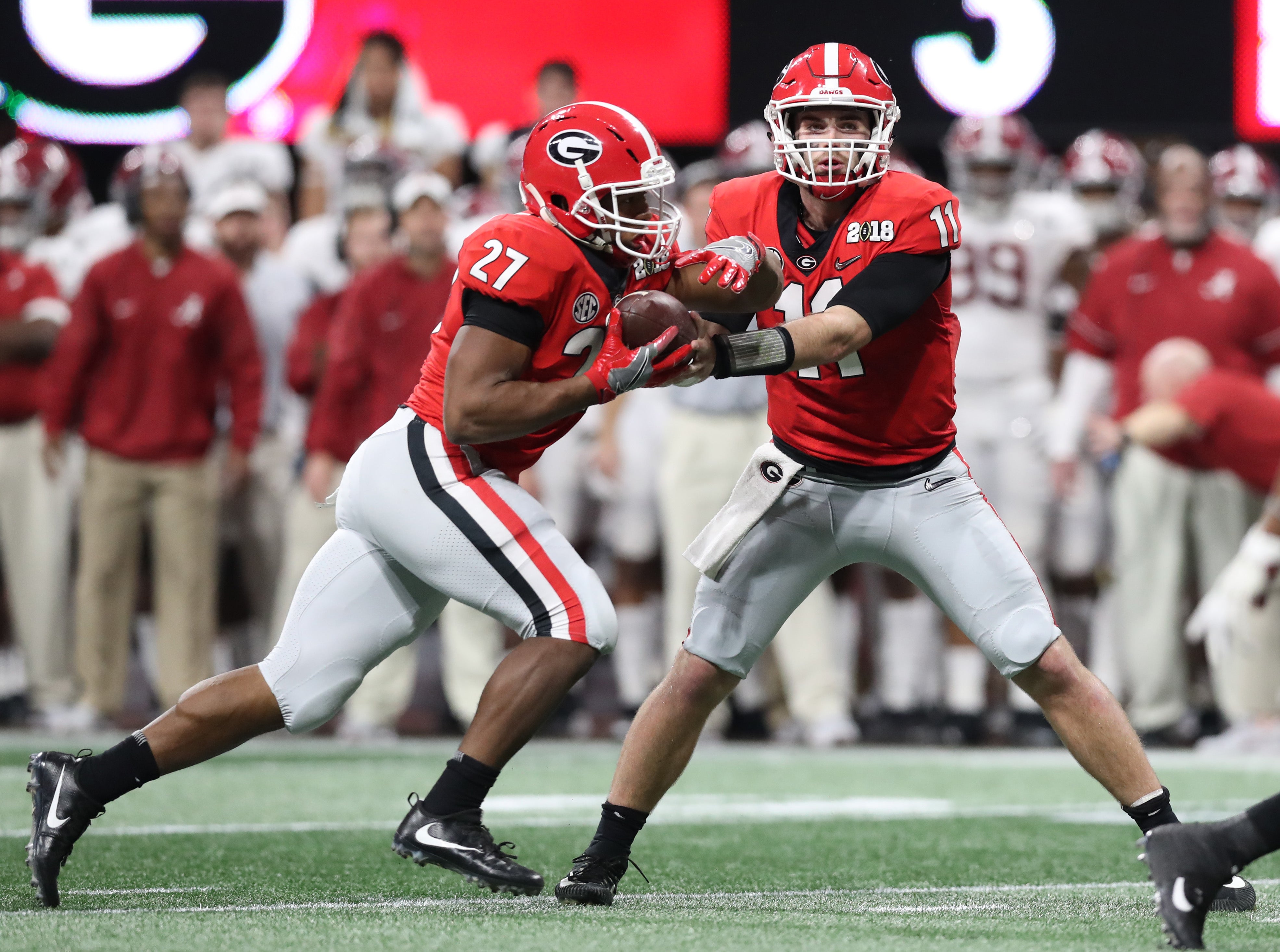 Georgia Bulldogs quarterback Jake Fromm (11) hands off the ball to running back Nick Chubb (27) against the Alabama Crimson Tide during the 2018 CFP national championship college football game.
