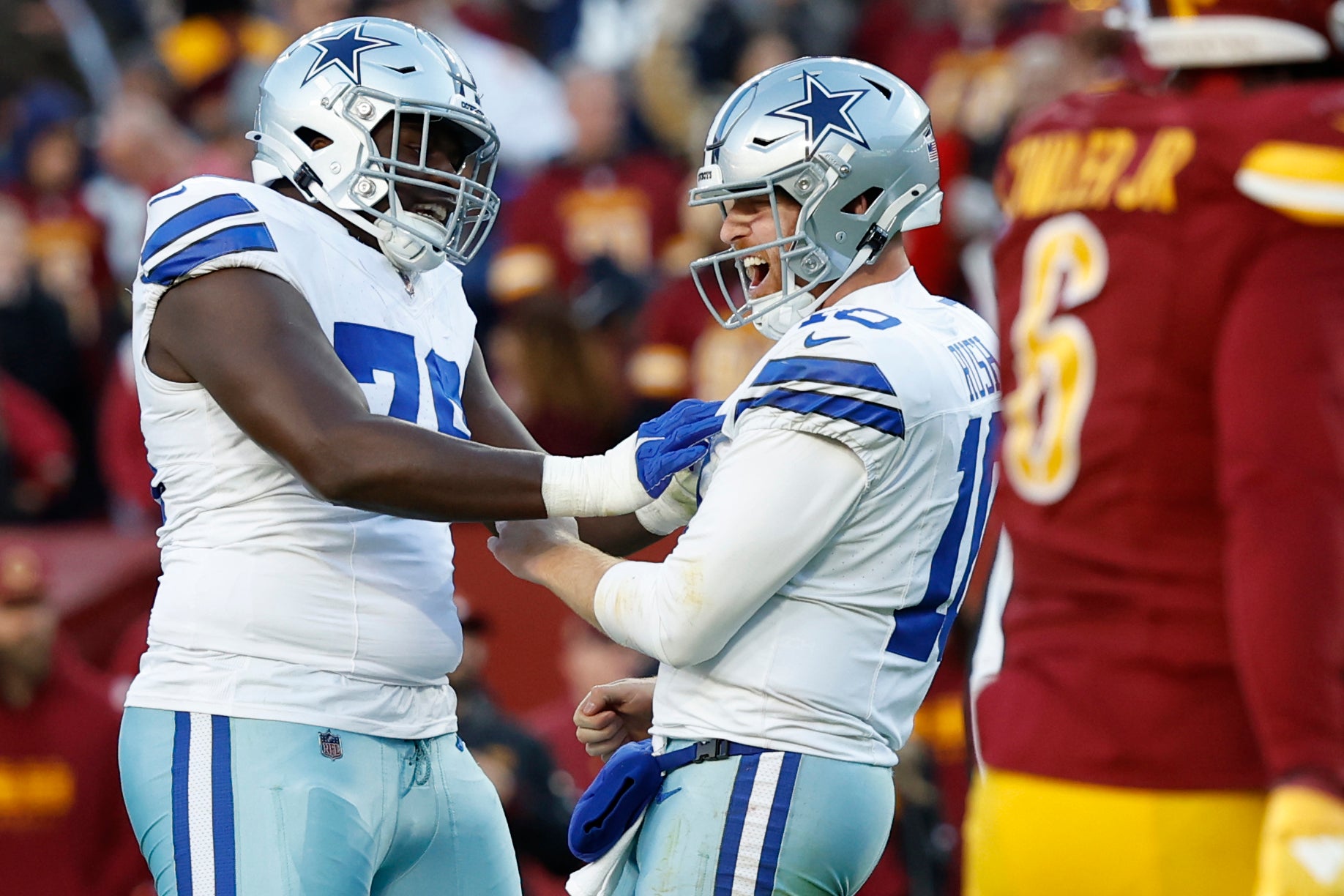Dallas Cowboys quarterback Cooper Rush (10) celebrates with Cowboys offensive tackle Asim Richards (76) after throwing a touchdown pass against the Washington Commanders during the fourth quarter at Northwest Stadium.