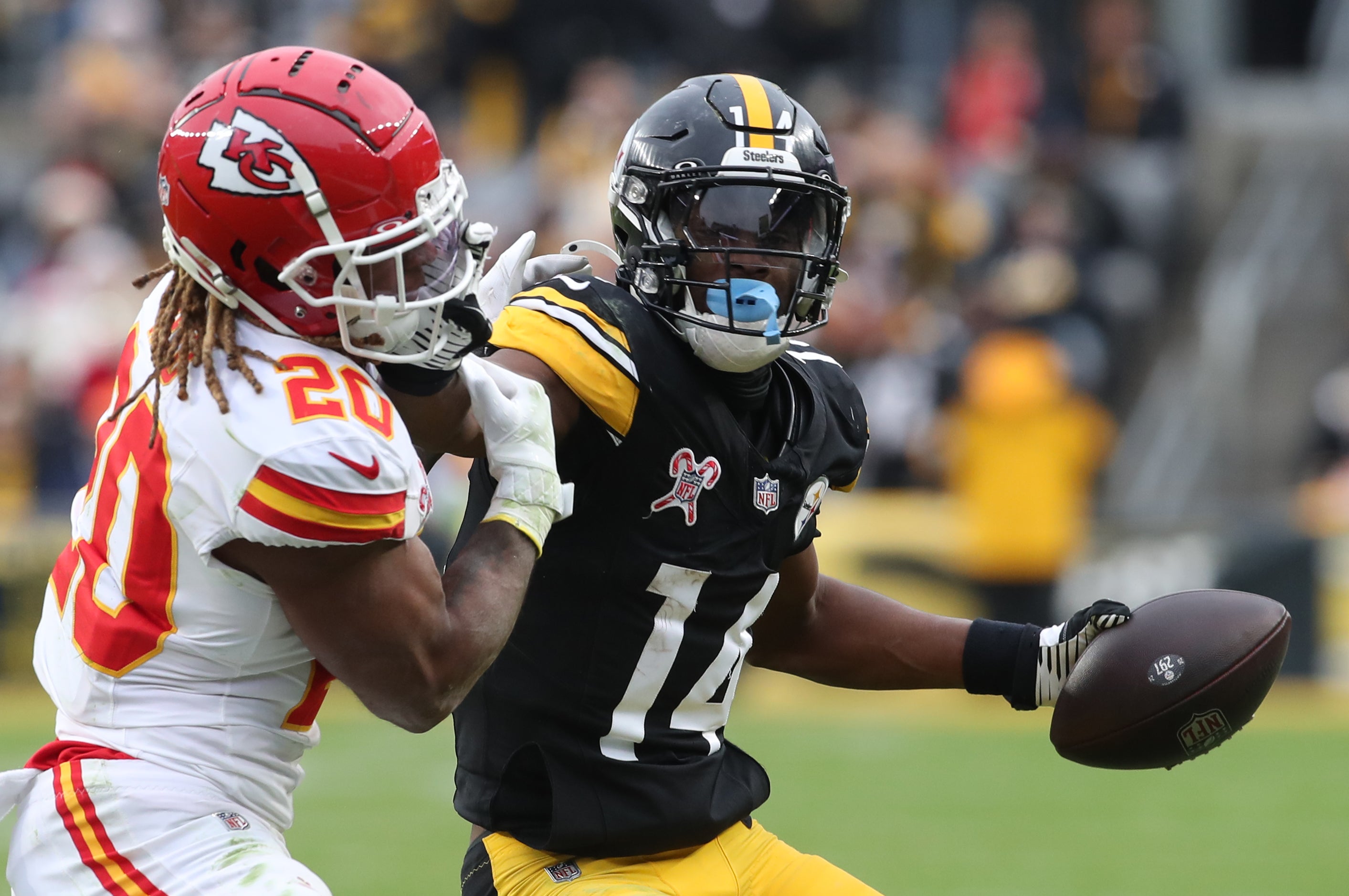 Dec 25, 2024; Pittsburgh, Pennsylvania, USA; Pittsburgh Steelers wide receiver George Pickens (14) runs after a catch as Kansas City Chiefs safety Justin Reid (20) defends during the fourth quarter at Acrisure Stadium.