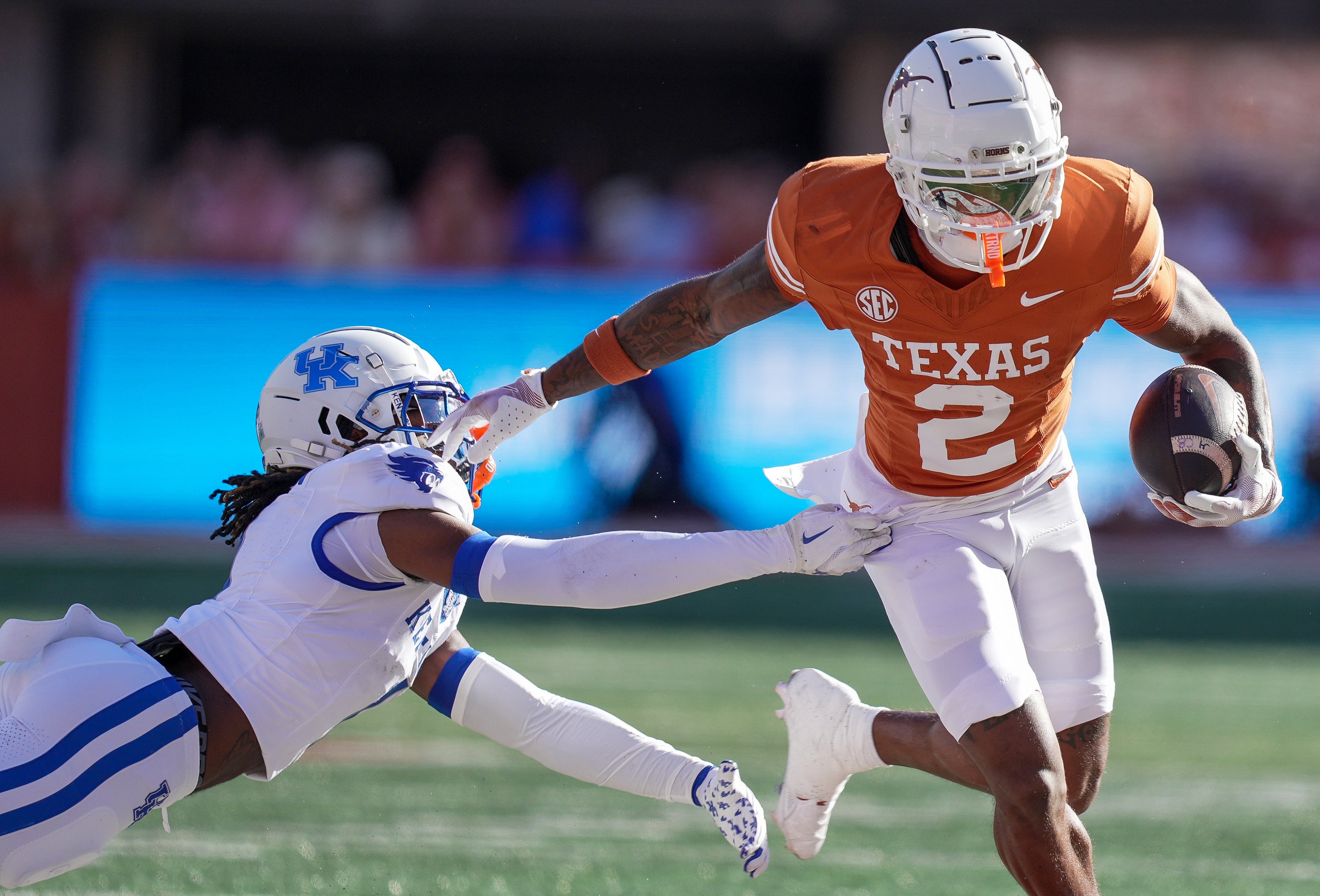 Texas Longhorns wide receiver Matthew Golden (2) stiff arms Kentucky Wildcats defensive back Maxwell Hairston (1) in the first quarter at Darrell K Royal Texas Memorial Stadium.