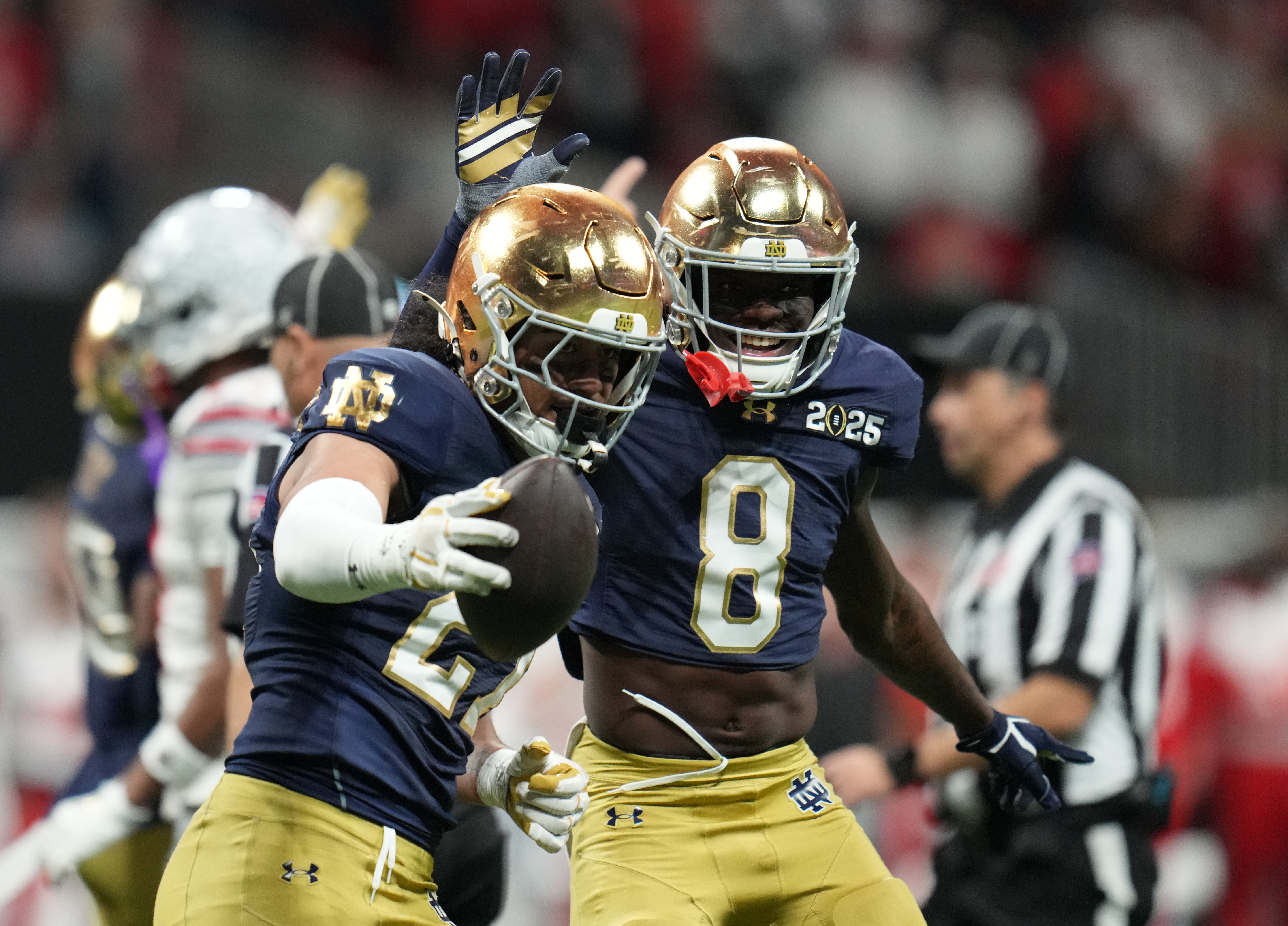 Notre Dame Fighting Irish linebacker Kyngstonn Viliamu-Asa (27) celebrates with Notre Dame Fighting Irish safety Adon Shuler (8) after recovering a fumble against the Ohio State Buckeyes in the second half in the CFP National Championship college football game at Mercedes-Benz Stadium.