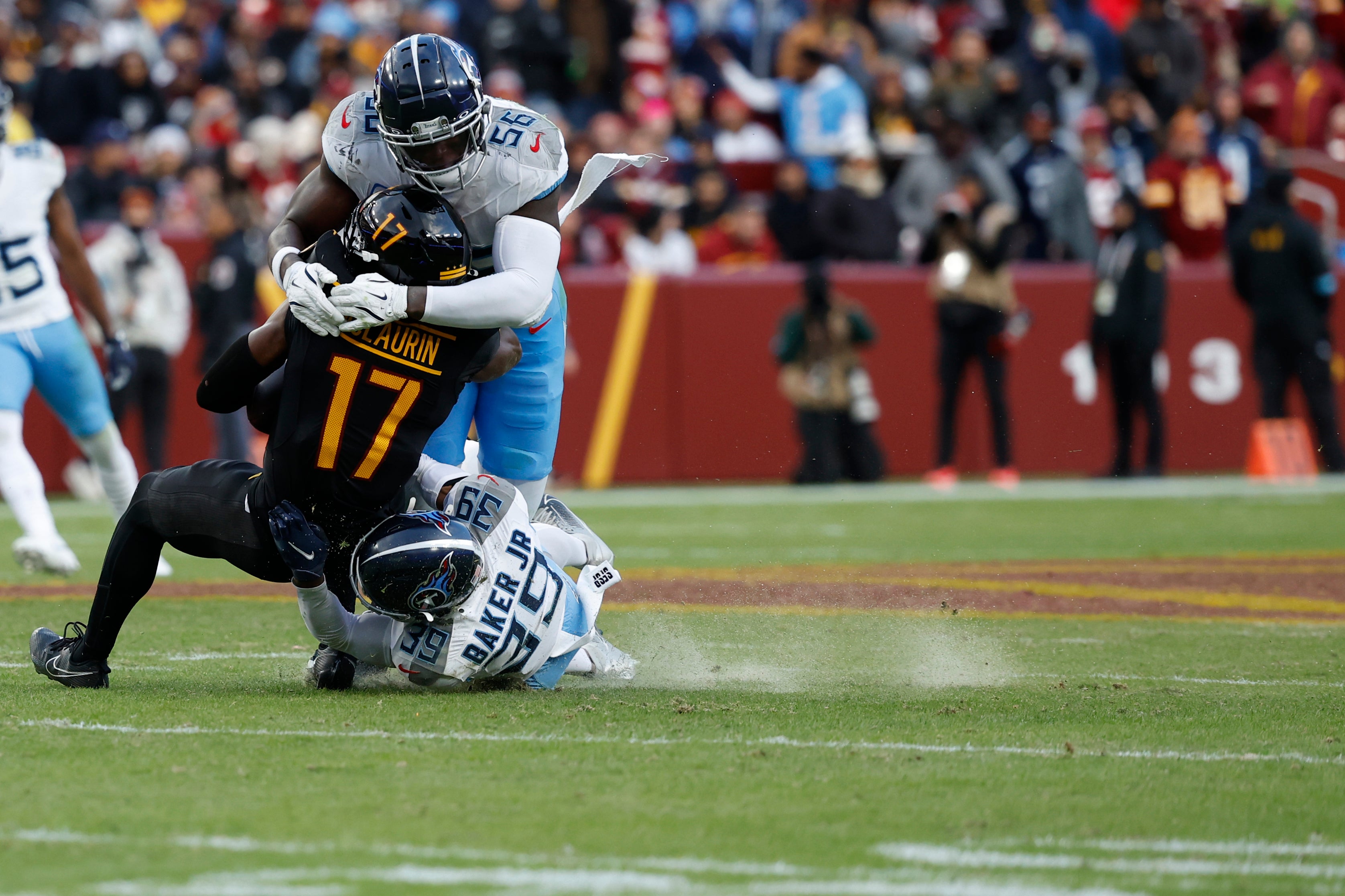 is tackled after making a catch by Tennessee Titans linebacker Kenneth Murray Jr. (56) and Titans cornerback Darrell Baker Jr. (39) during the fourth quarter at Northwest Stadium.