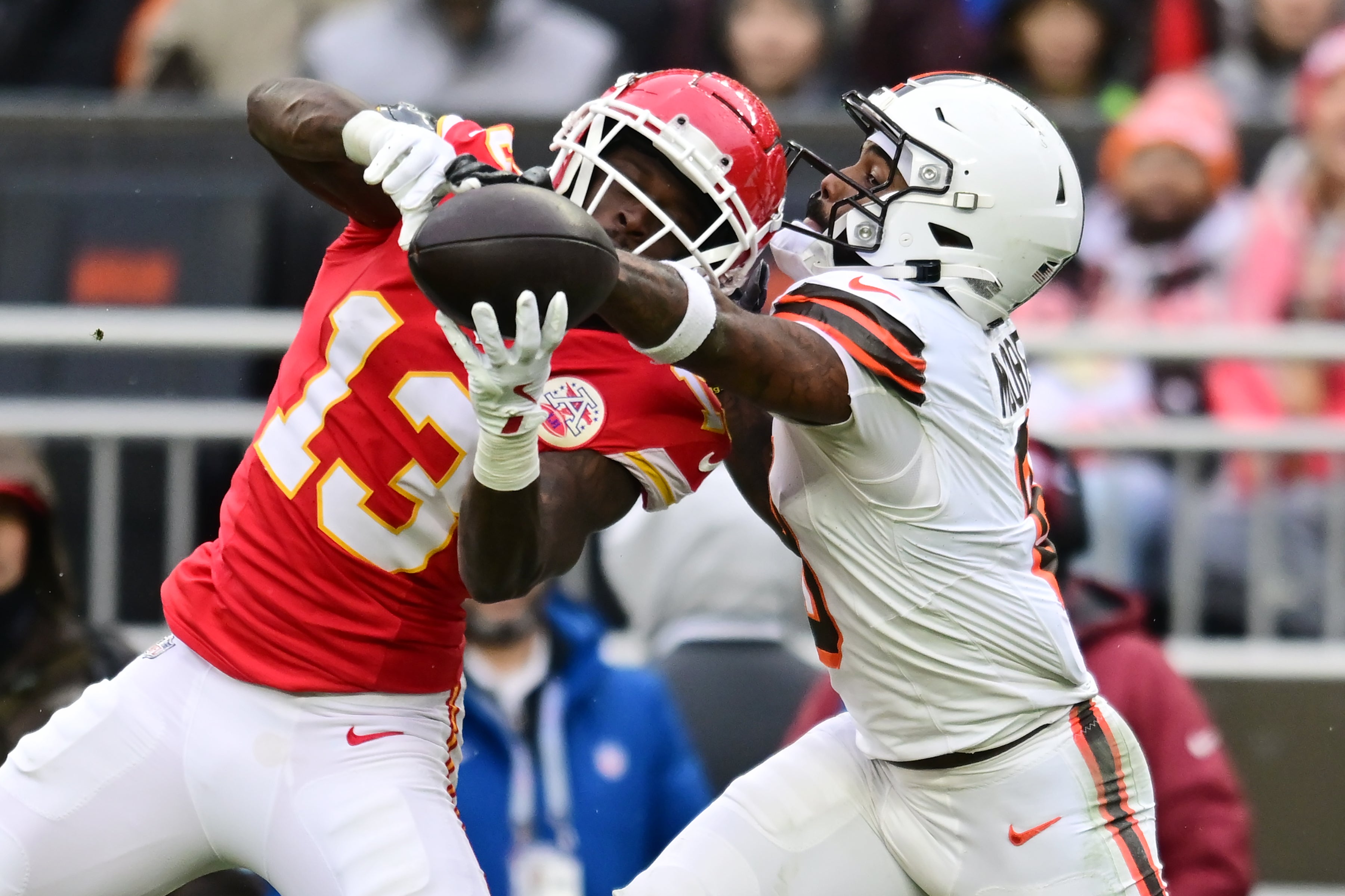 Dec 15, 2024; Cleveland, Ohio, USA; Kansas City Chiefs safety Nazeeh Johnson (13) and Cleveland Browns wide receiver Elijah Moore (8) go for a pass during the first half at Huntington Bank Field.