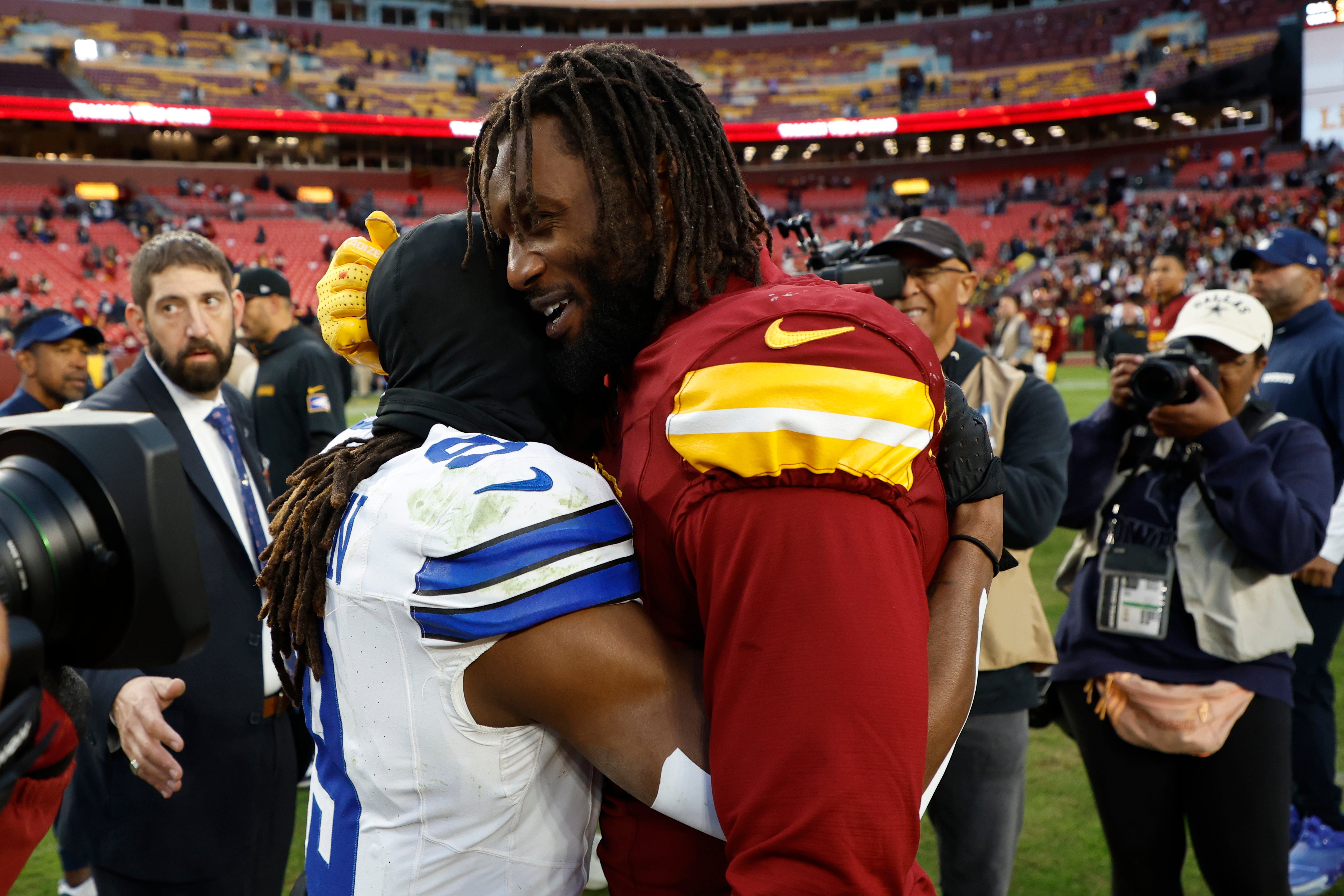 Dallas Cowboys wide receiver KaVontae Turpin (9) hugs Washington Commanders linebacker Dante Fowler Jr. (6) after their game at Northwest Stadium.