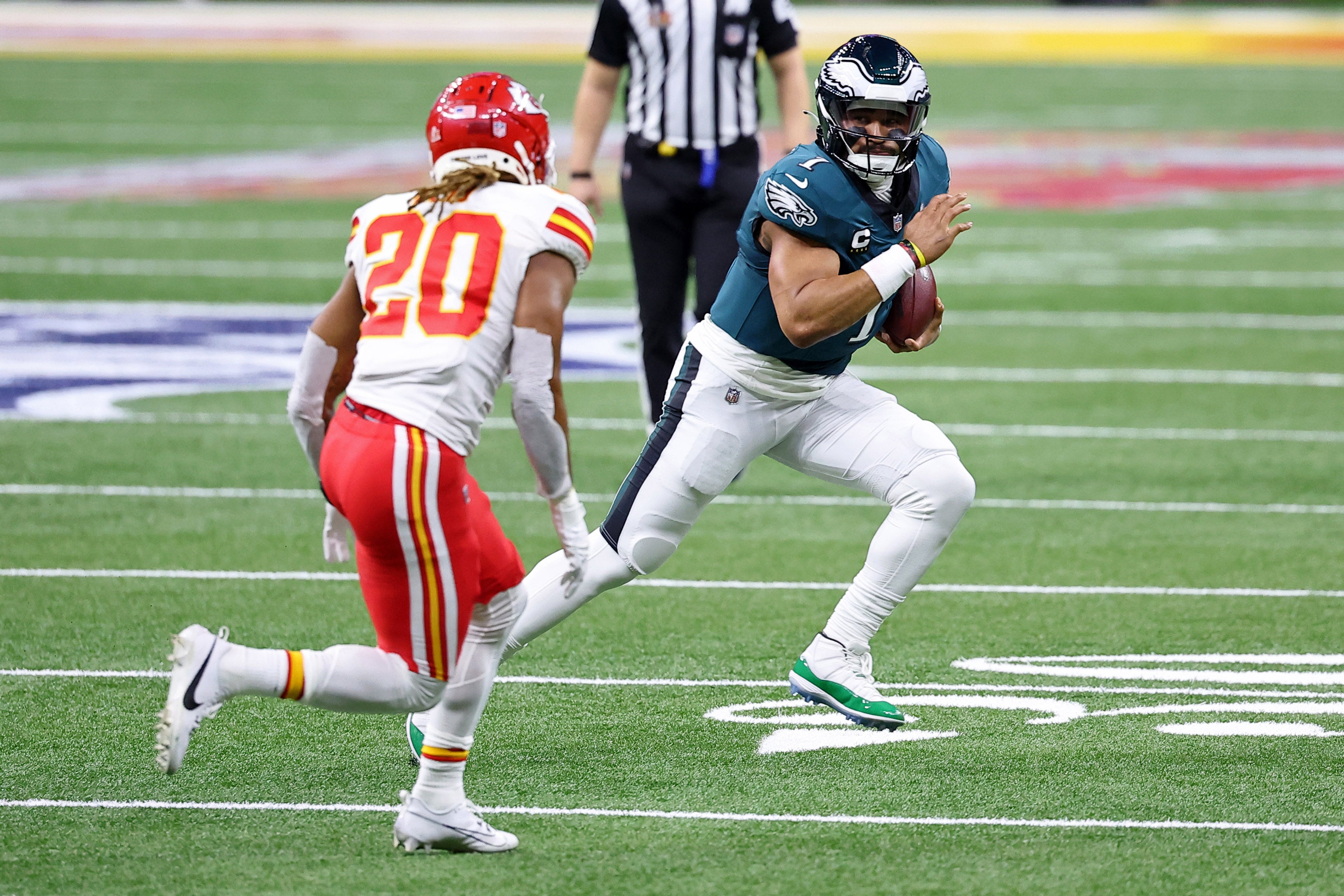 Philadelphia Eagles quarterback Jalen Hurts (1) runs with the ball against Kansas City Chiefs safety Justin Reid (20) during the first half of Super Bowl LIX at Caesars Superdome.