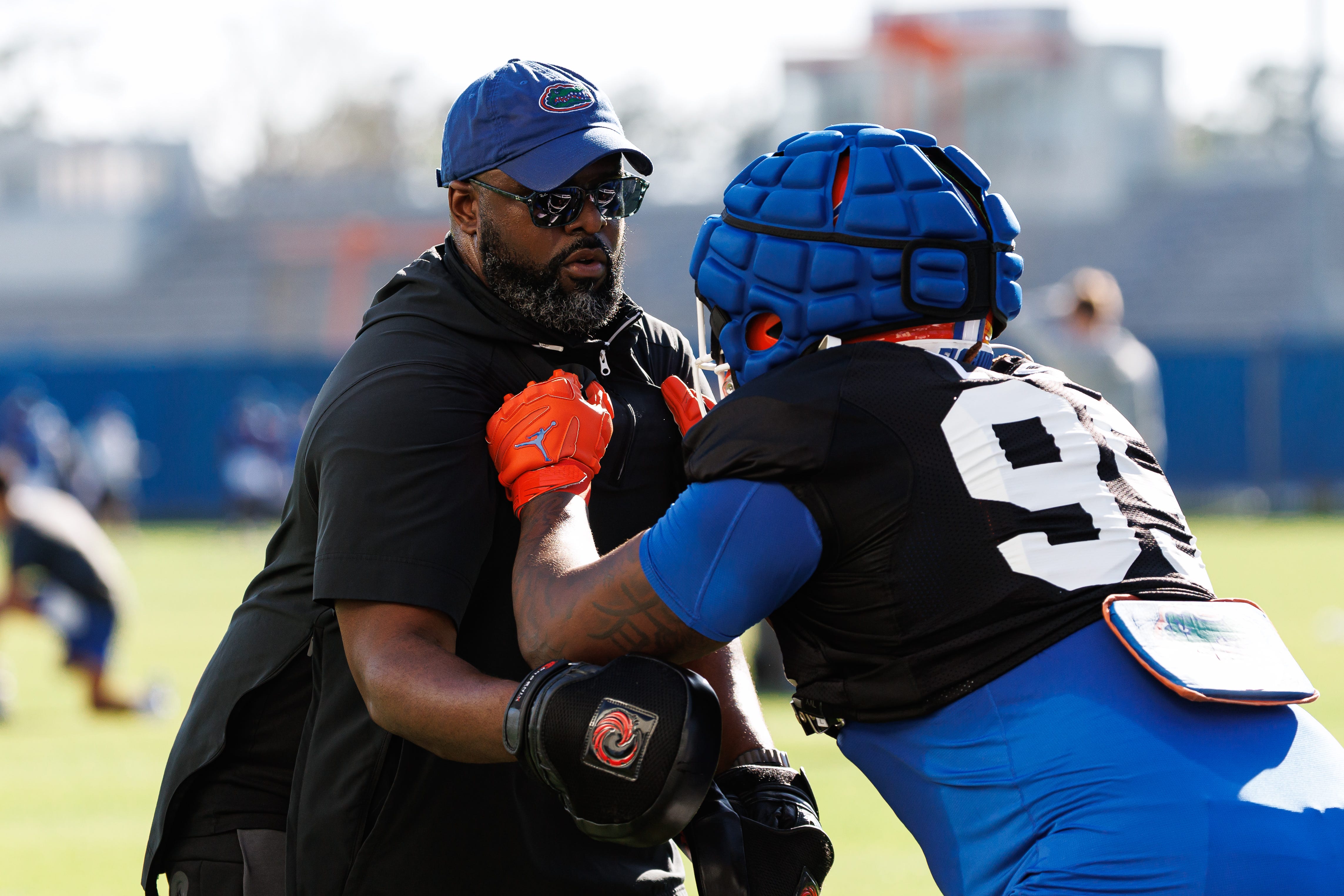 Florida Gators assistant coach for defensive line Gerald Chatman participates in a drill with Florida Gators defensive lineman Jamari Lyons (95) during spring football practice at the Sanders Practice Fields