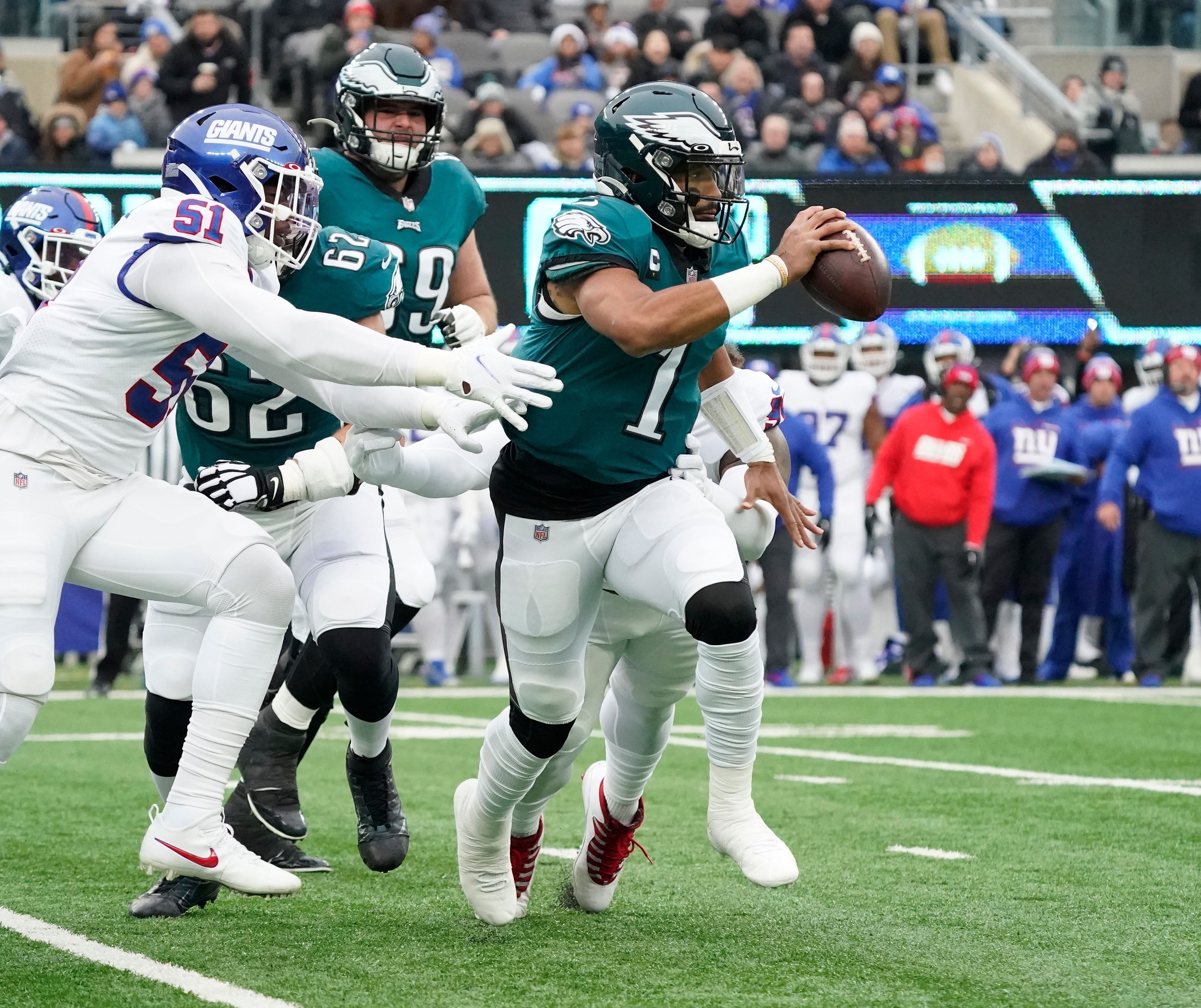 Philadelphia Eagles quarterback Jalen Hurts (1) breaks away from pressure from New York Giants outside linebacker Azeez Ojulari (51) at MetLife Stadium.