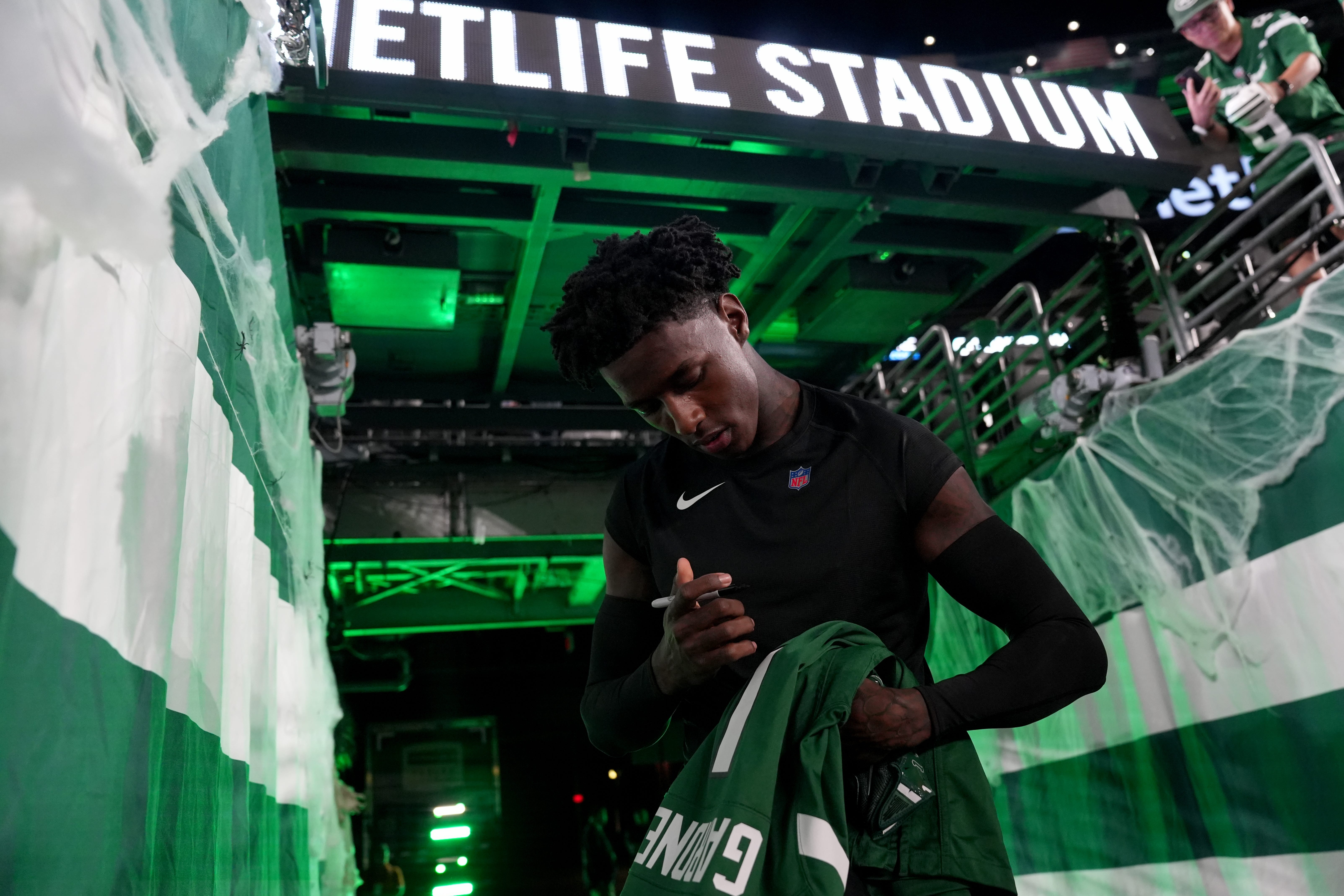 New York Jets cornerback Sauce Gardner (1) signs an autograph for a fan before the game, Thursday, October 31, 2024, in East Rutherford.