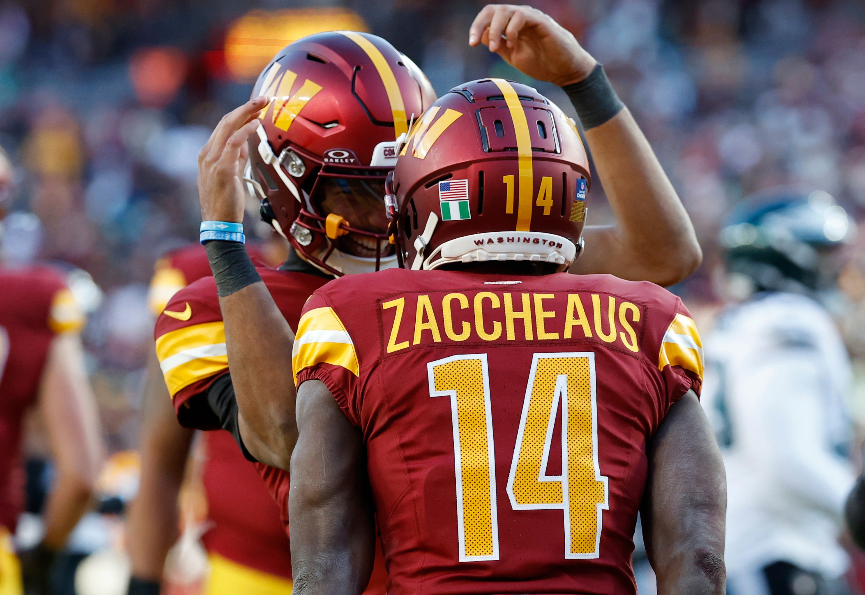 Dec 22, 2024; Landover, Maryland, USA; Washington Commanders wide receiver Olamide Zaccheaus (14) celebrates with Commanders quarterback Jayden Daniels (5) after connecting on a touchdown pass against the Philadelphia Eagles during the fourth quarter at Northwest Stadium.