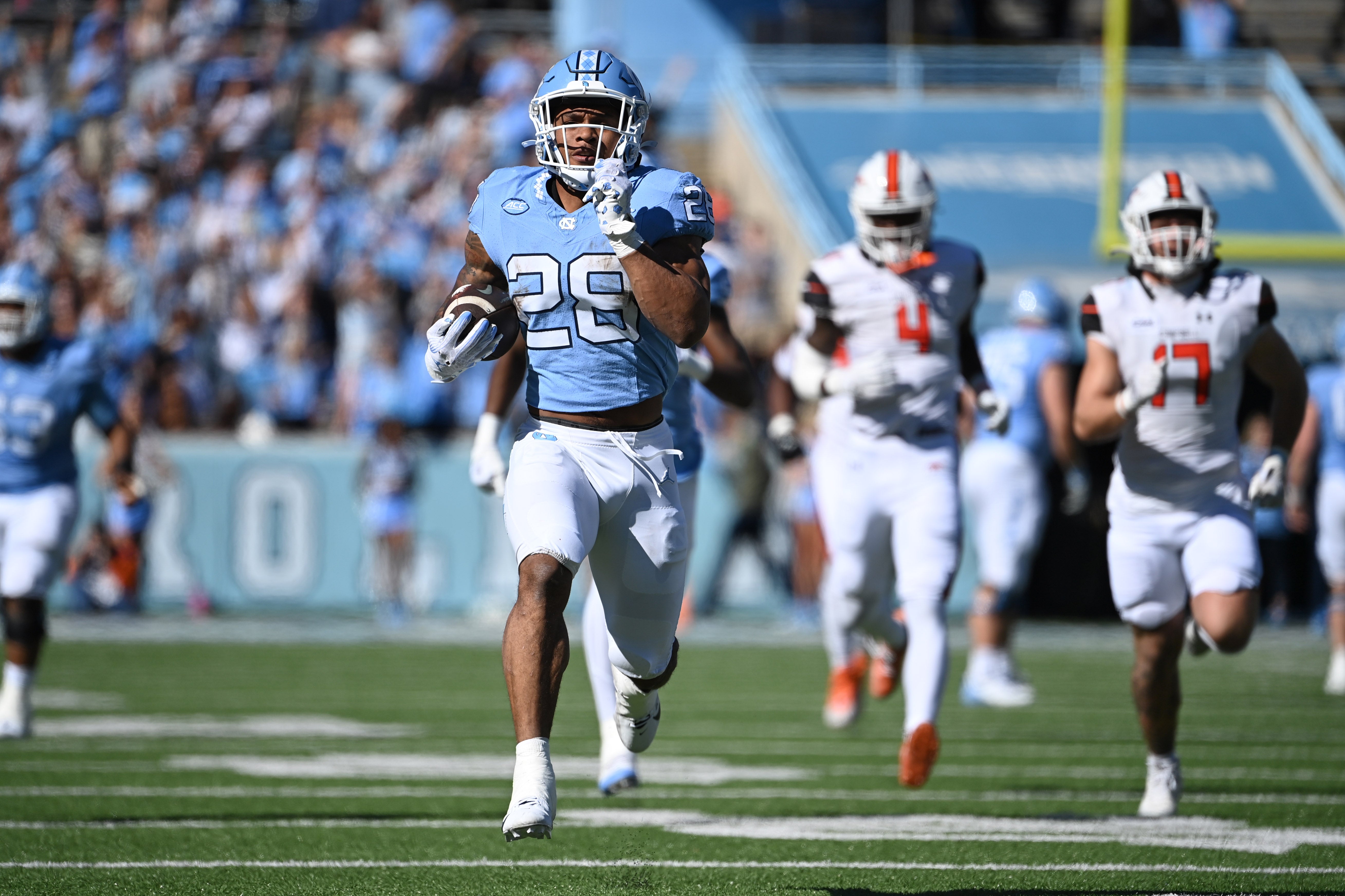 Nov 4, 2023; Chapel Hill, North Carolina, USA; North Carolina Tar Heels running back Omarion Hampton (28) runs as Campbell Fighting Camels linebacker Monchovia Gaffney (4) and linebacker Taylor Behl (17) defend in the first quarter at Kenan Memorial Stadium.