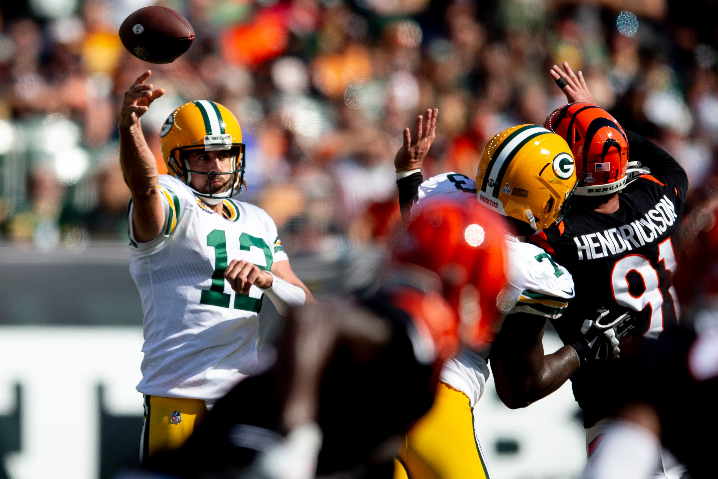 Green Bay Packers quarterback Aaron Rodgers (12) throws a pass as Cincinnati Bengals defensive end Trey Hendrickson (91) attempts to deflect it in the second half of the NFL football game on Sunday, Oct. 10, 2021, at Paul Brown Stadium in Cincinnati. Green Bay Packers defeated Cincinnati Bengals 25-22 in overtime. Green Bay Packers At Cincinnati Bengals 59