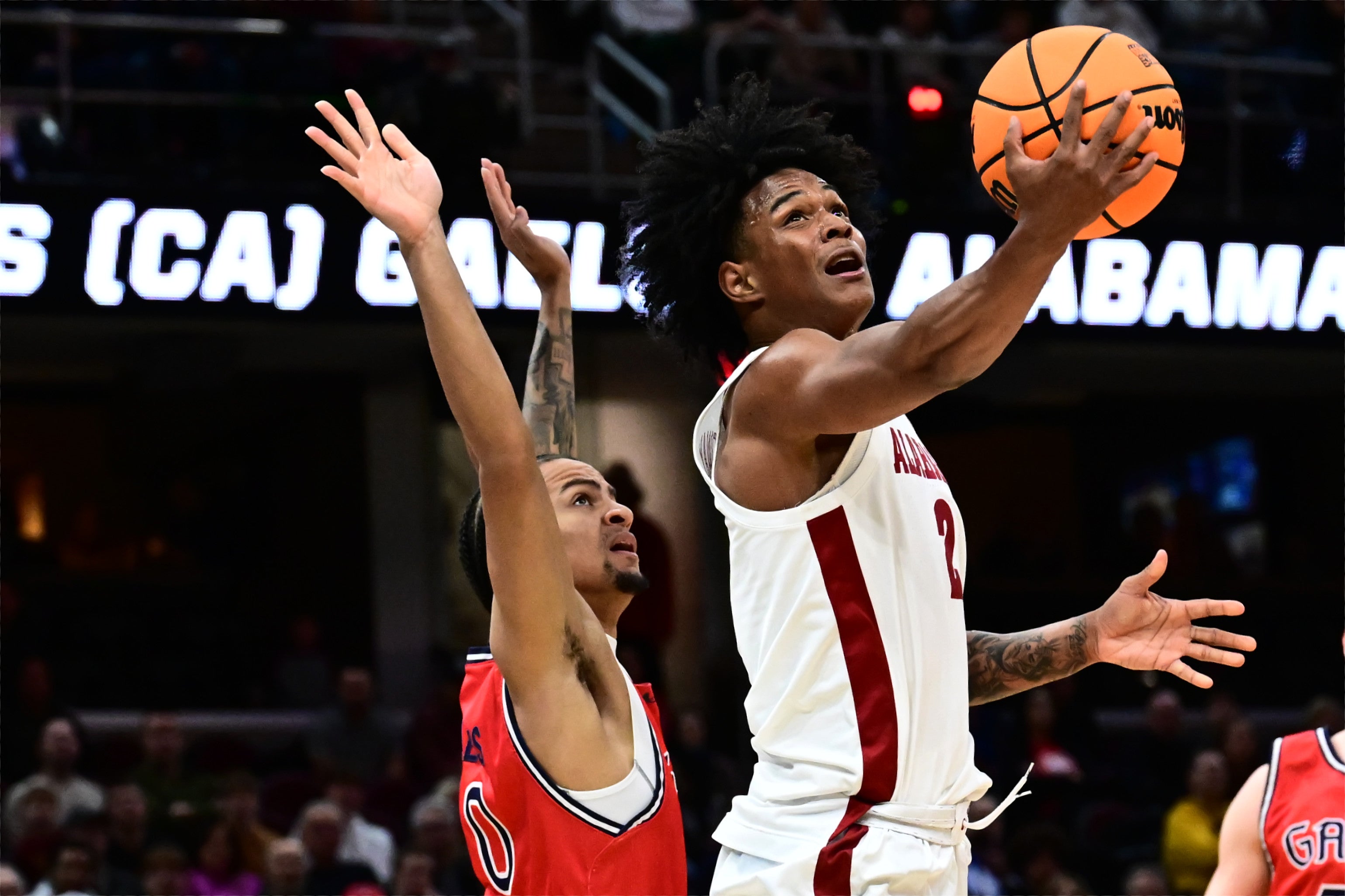 Mar 23, 2025; Cleveland, OH, USA; Alabama Crimson Tide guard Aden Holloway (2) shoots the ball defended by St. Mary's Gaels guard Mikey Lewis (0) in the first half during the NCAA Tournament Second Round at Rocket Arena.