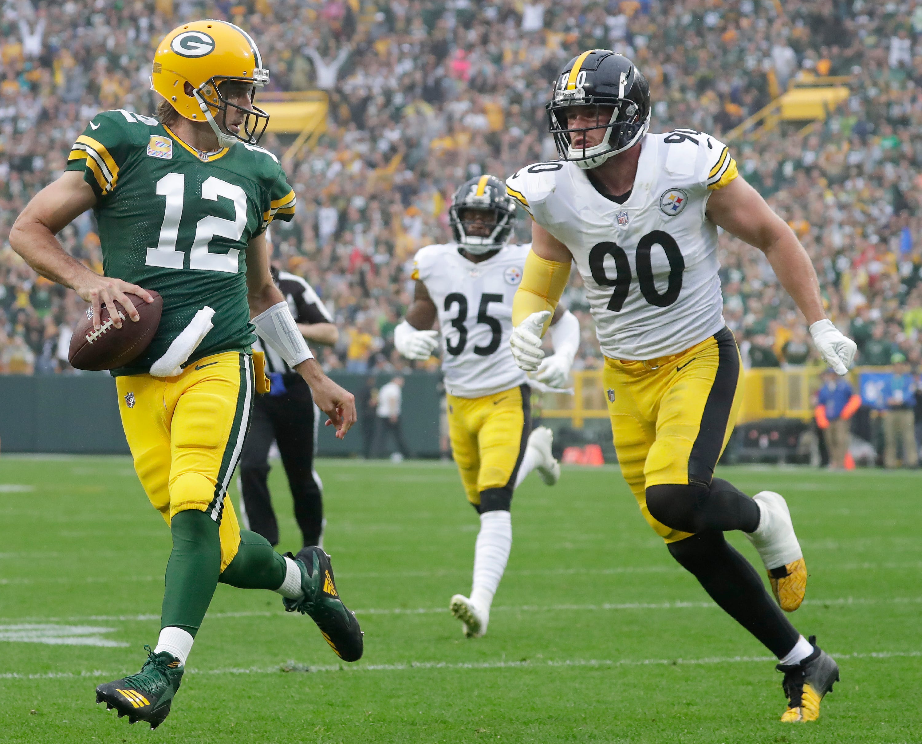 Green Bay Packers quarterback Aaron Rodgers (12) scrambles for a touchdown in the second quarter against Pittsburgh Steelers linebacker T.J. Watt (90) during their football game on Sunday, October 3, 2021, at Lambeau Field in Green Bay, Wis.