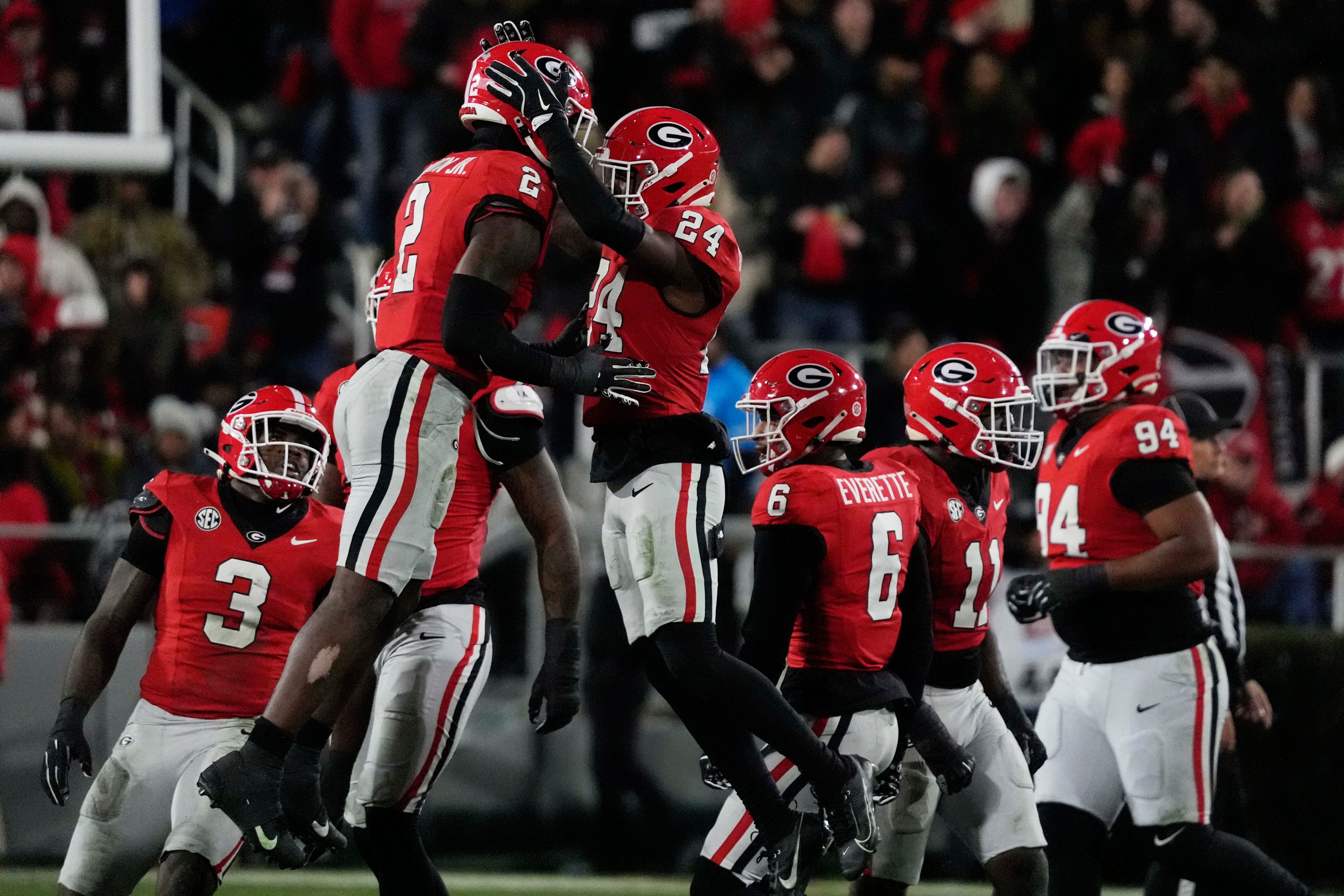 Georgia linebacker Smael Mondon Jr. (2) and Georgia defensive back Malaki Starks (24) celebrate after making a stop during the first half of a NCAA college football game against Georgia Tech in Athens, Ga., on Friday, Nov. 29, 2024.