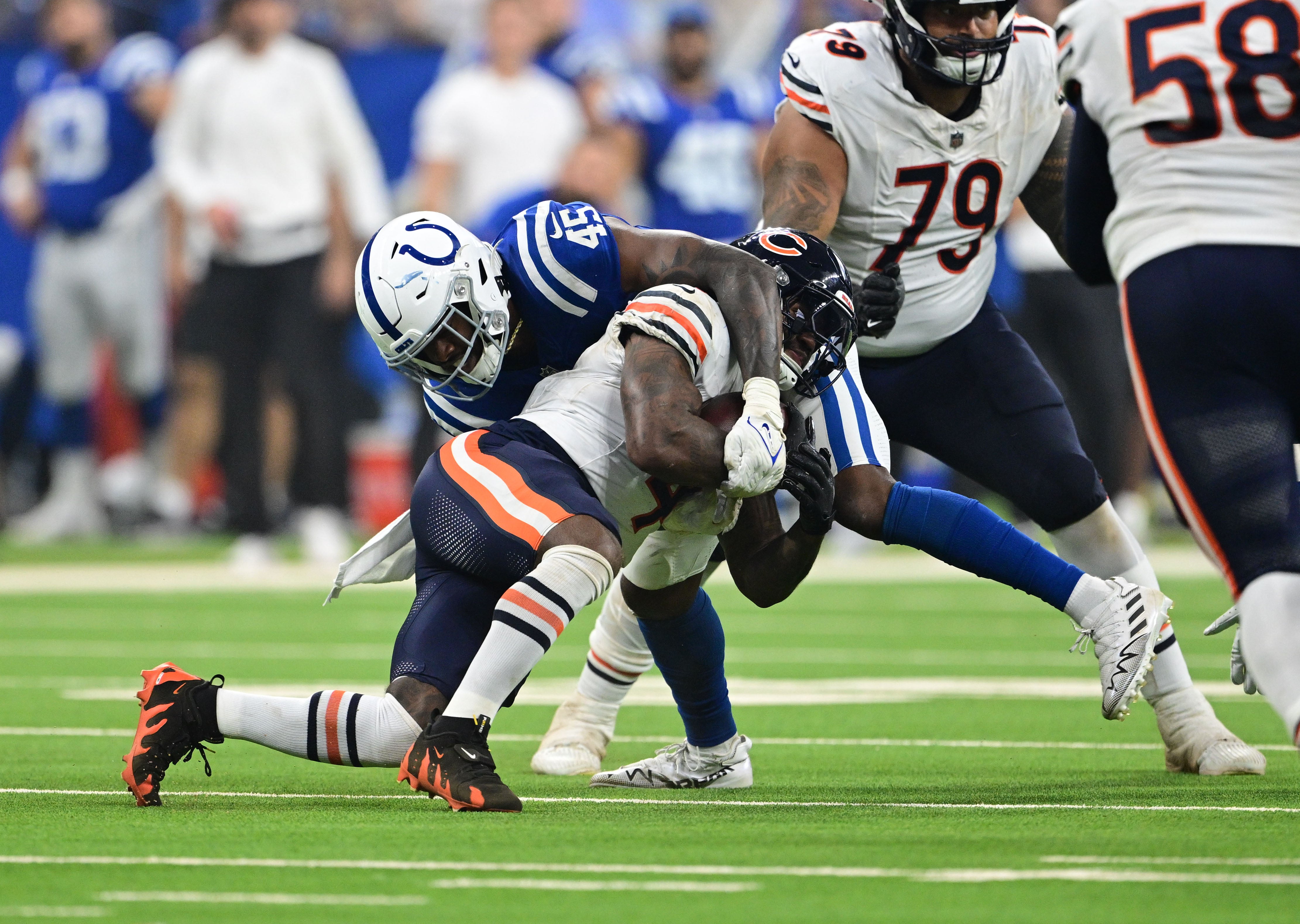 Sep 22, 2024; Indianapolis, Indiana, USA; Chicago Bears running back D'Andre Swift (4) is tackled but Indianapolis Colts linebacker E.J. Speed (45) during the second quarter at Lucas Oil Stadium.
