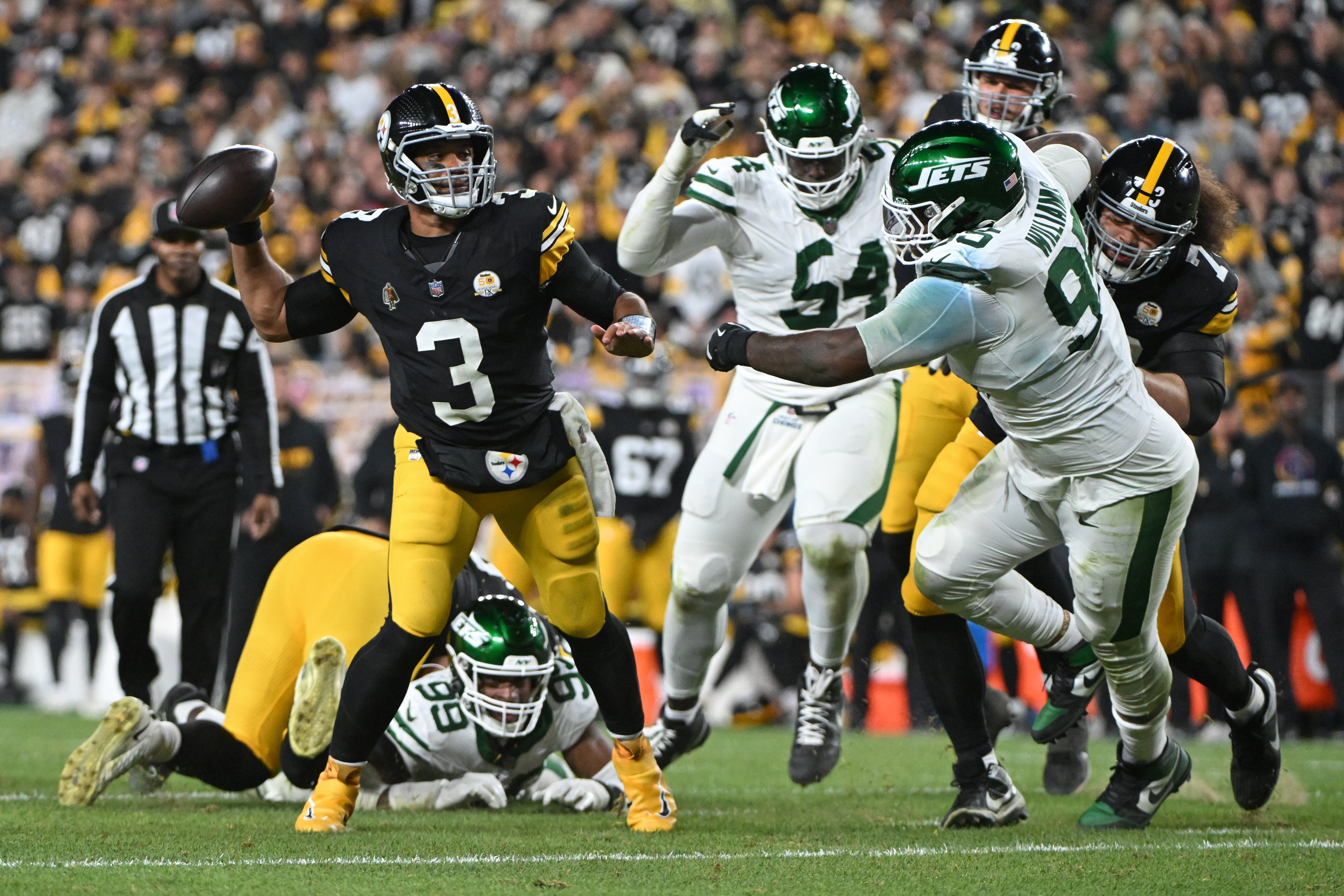 Pittsburgh Steelers quarterback Russell Wilson (3) throws pass while being pressured by New York Jets defensive tackle Quinnen Williams (95) during the second quarter at Acrisure Stadium.