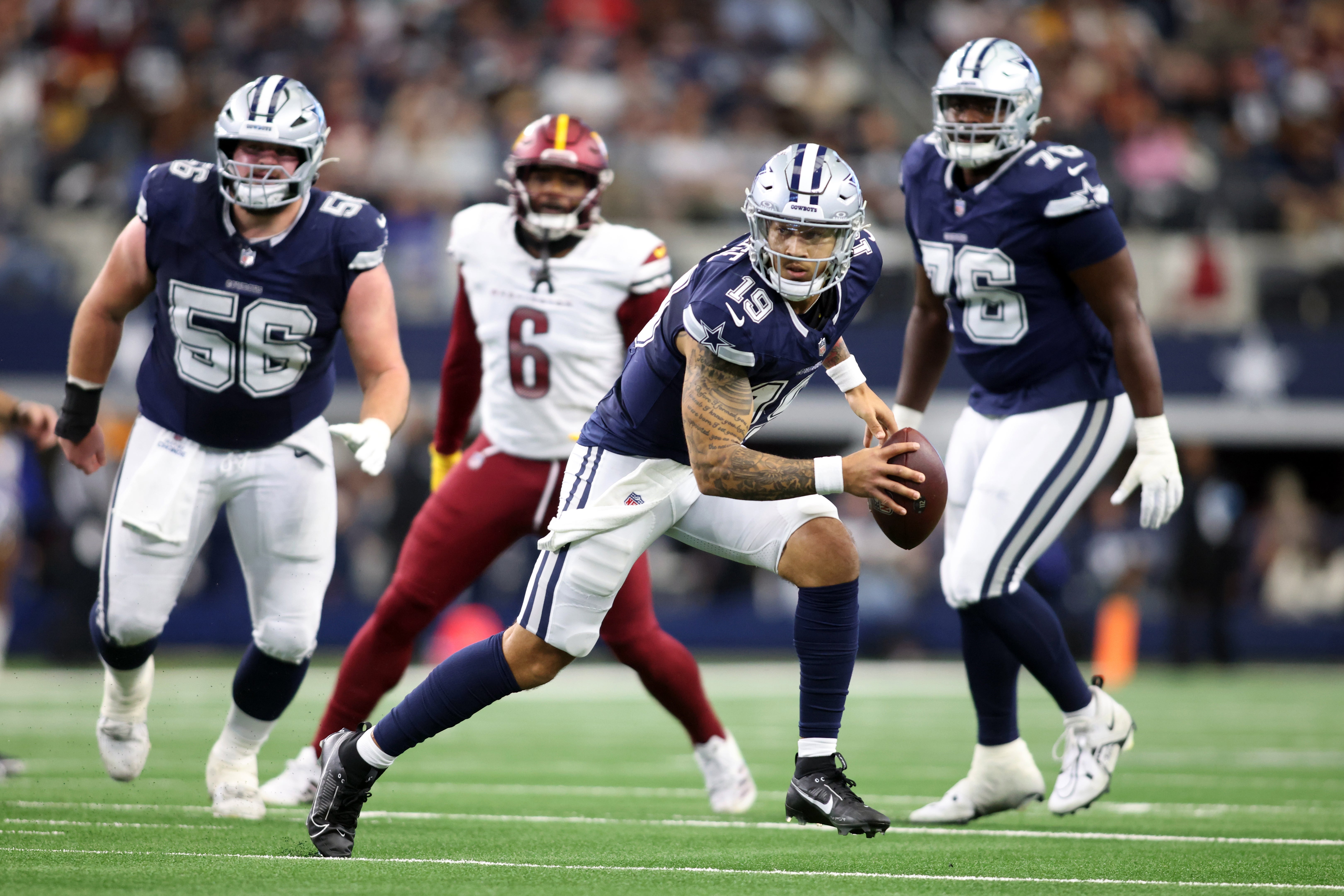Dallas Cowboys quarterback Trey Lance (19) scrambles in the pocket against the Washington Commanders during the fourth quarter at AT&T Stadium.