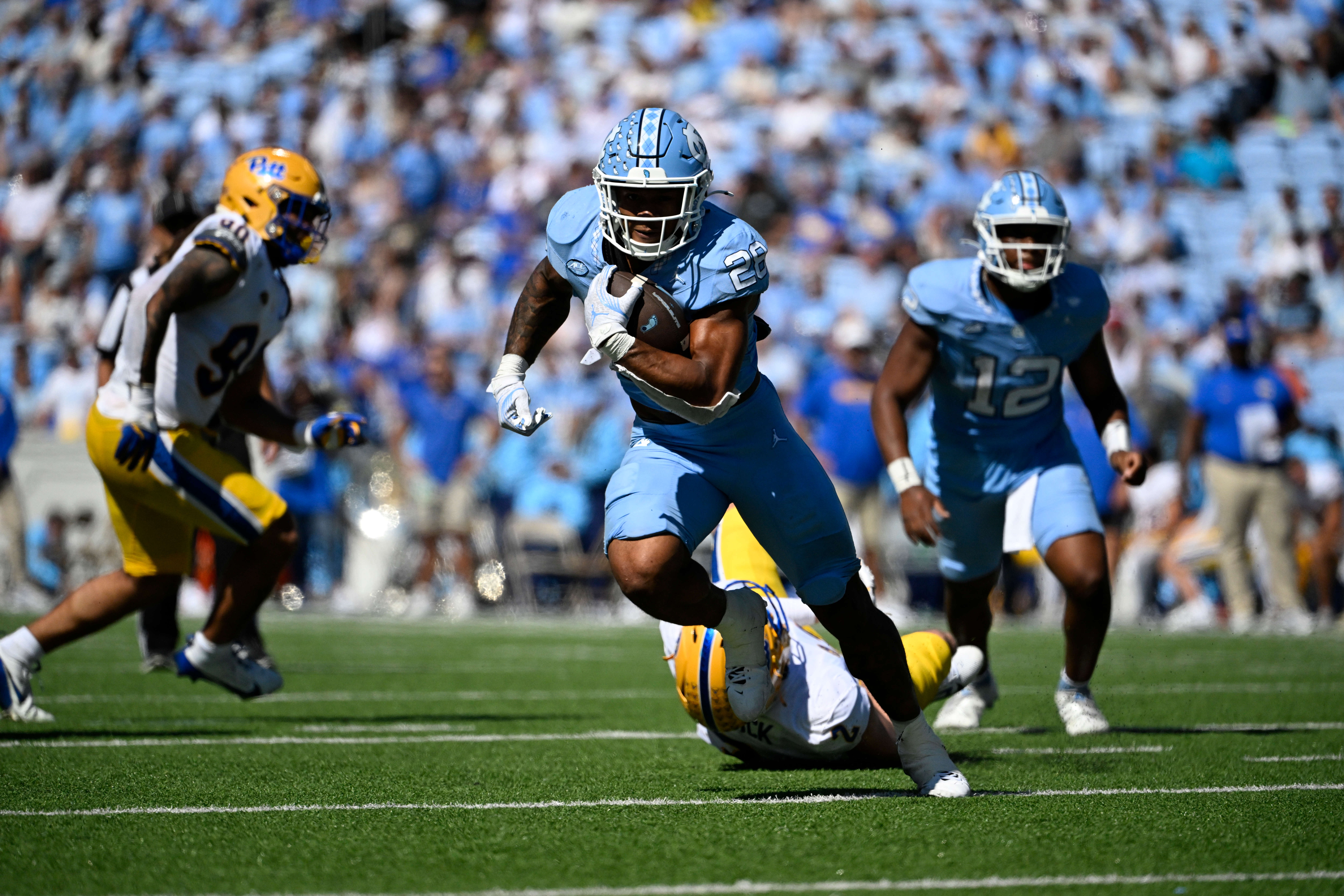 Oct 5, 2024; Chapel Hill, North Carolina, USA; North Carolina Tar Heels running back Omarion Hampton (28) riuns with the ball as Pittsburgh Panthers defensive lineman Nate Matlack (2) defends in the second quarter at Kenan Memorial Stadium.