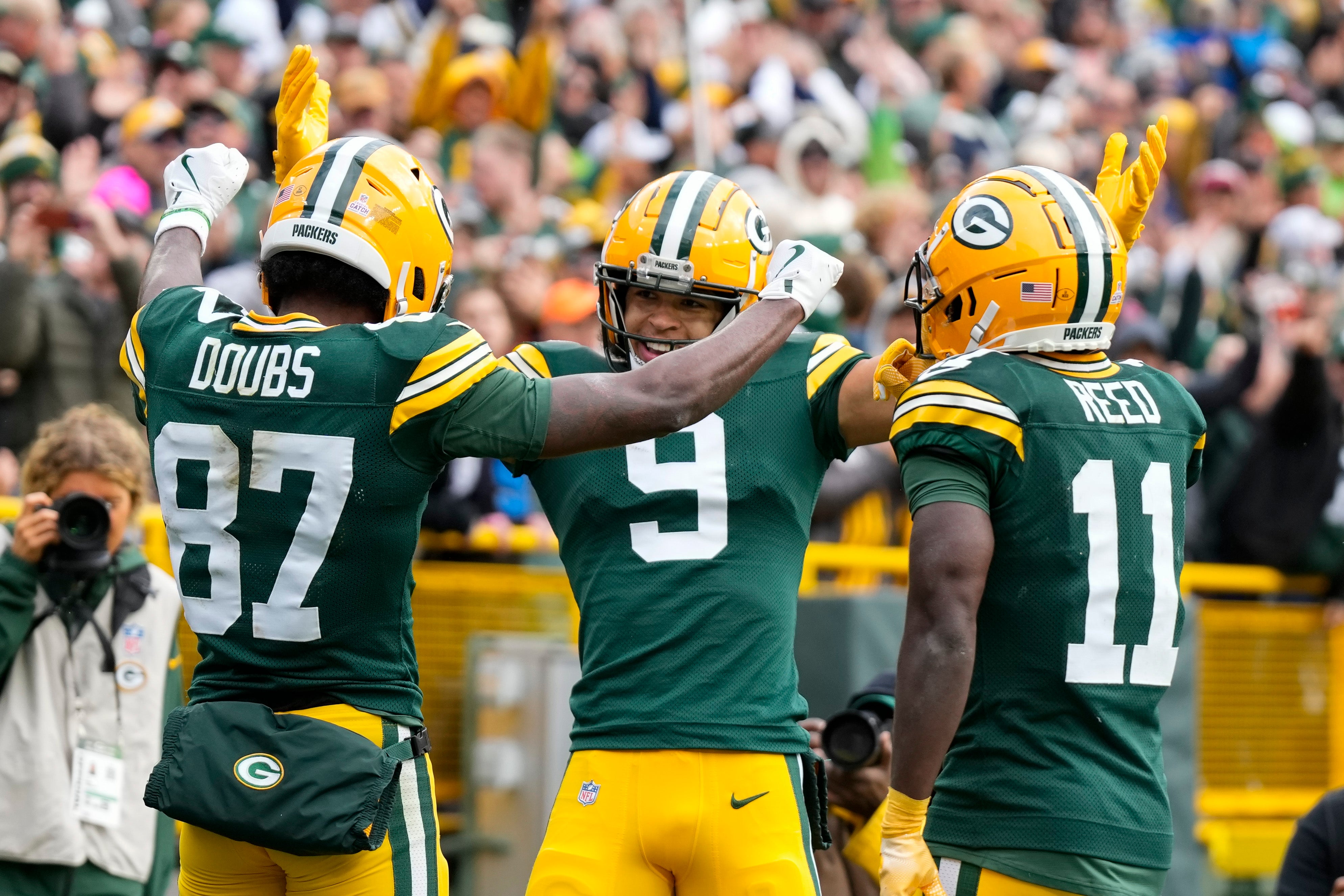 Green Bay Packers wide receiver Romeo Doubs (87) celebrates with wide receivers Christian Watson (9) and Jayden Reed (11) after scoring a touchdown during the third quarter against the Arizona Cardinals at Lambeau Field.