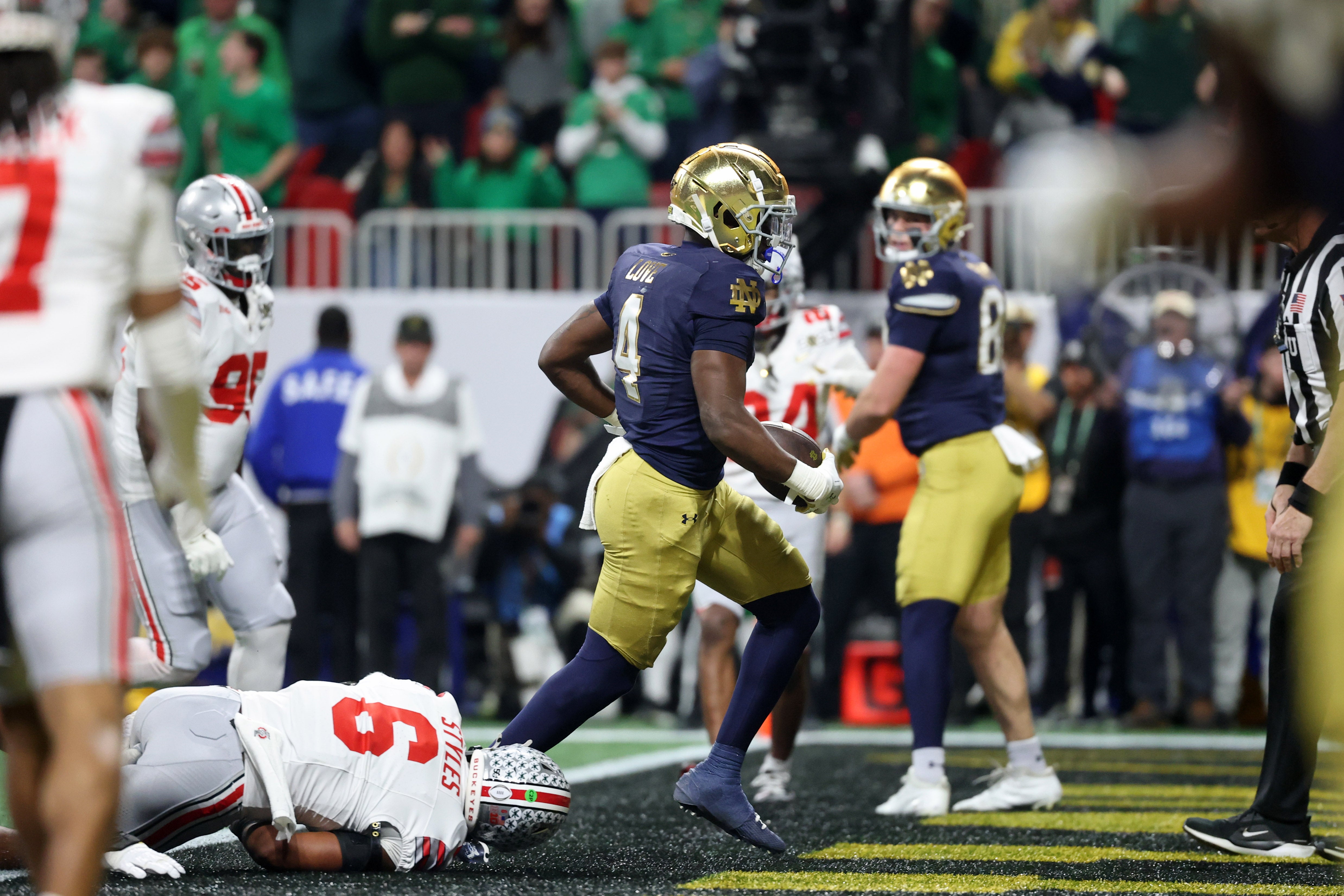 Notre Dame Fighting Irish running back Jeremiyah Love (4) scores a two-point conversion against the Ohio State Buckeyes during the second half the CFP National Championship college football game at Mercedes-Benz Stadium.