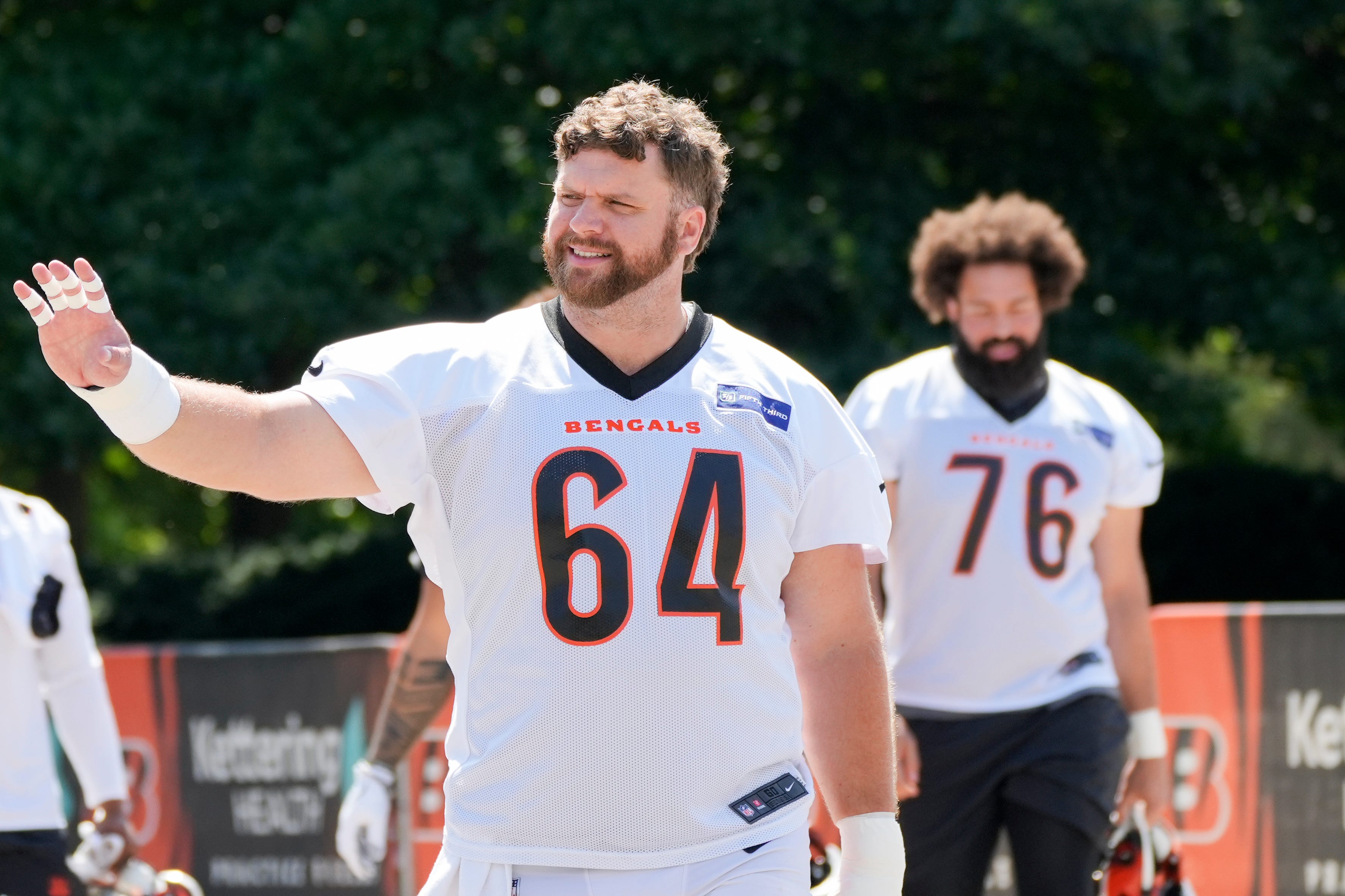 Cincinnati Bengals center Ted Karras (64) waves to a fan as he’s walking towards the field at Bengals practice, Tuesday, June 4, 2024, in Cincinnati.  