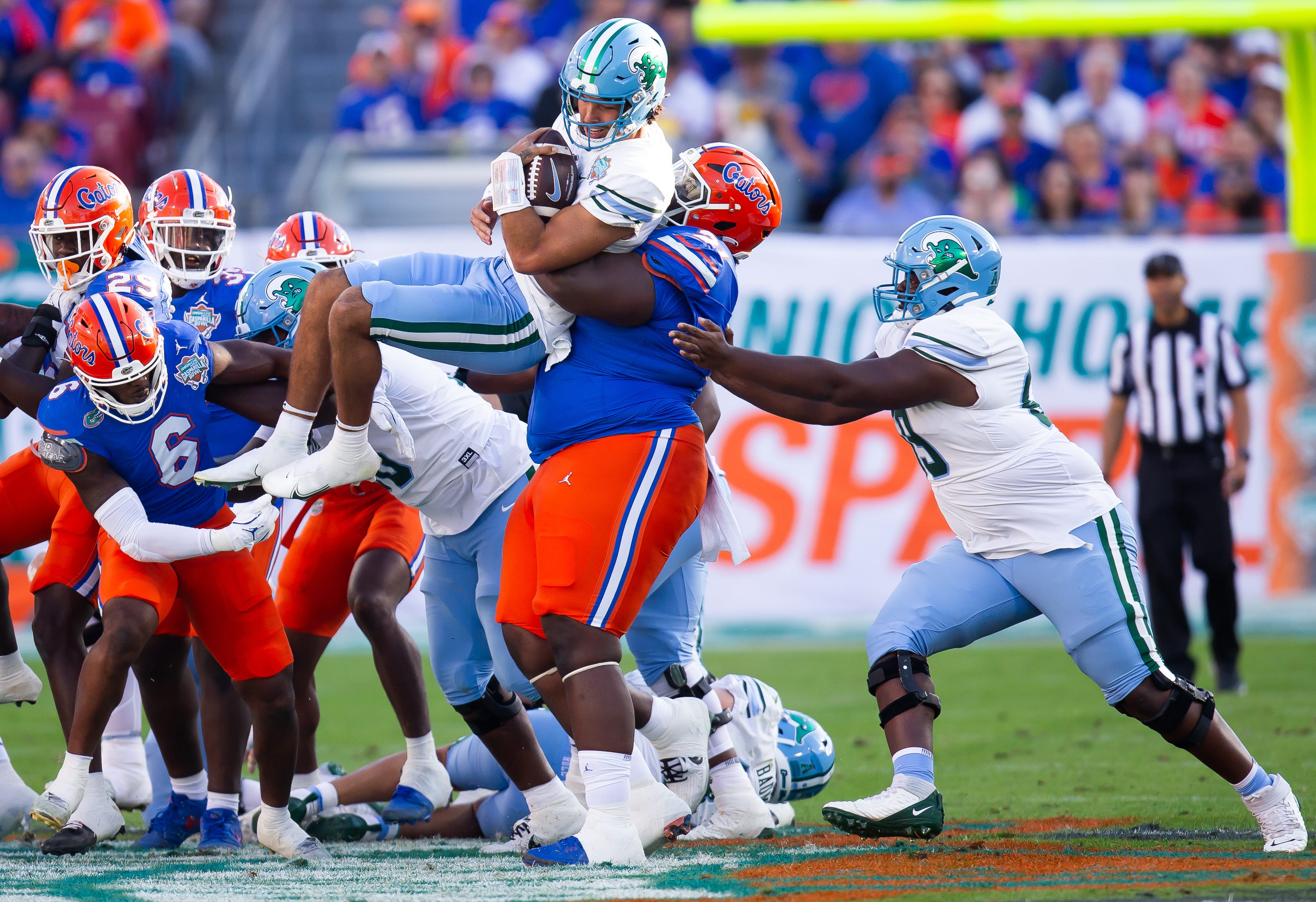Florida Gators defensive lineman Desmond Watson (21) tackles Tulane Green Wave quarterback Ty Thompson (7) during the first half at Raymond James Stadium in Tampa, FL on Friday, December 20, 2024 in the 2024 Union Home Mortgage Gasparilla Bowl.