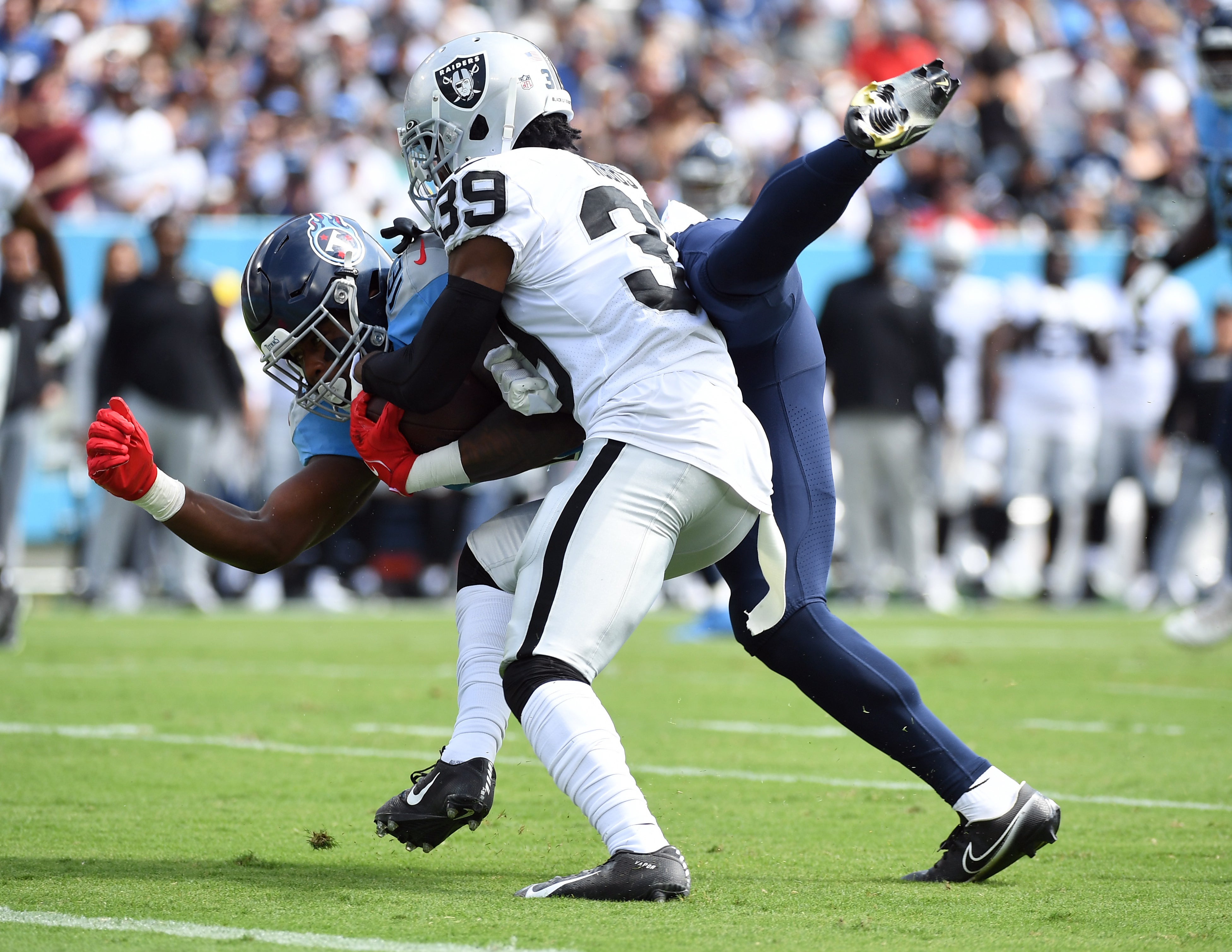 Tennessee Titans wide receiver Treylon Burks (16) is hit by Las Vegas Raiders cornerback Nate Hobbs (39) as he dives short of the end zone during the first half at Nissan Stadium. 