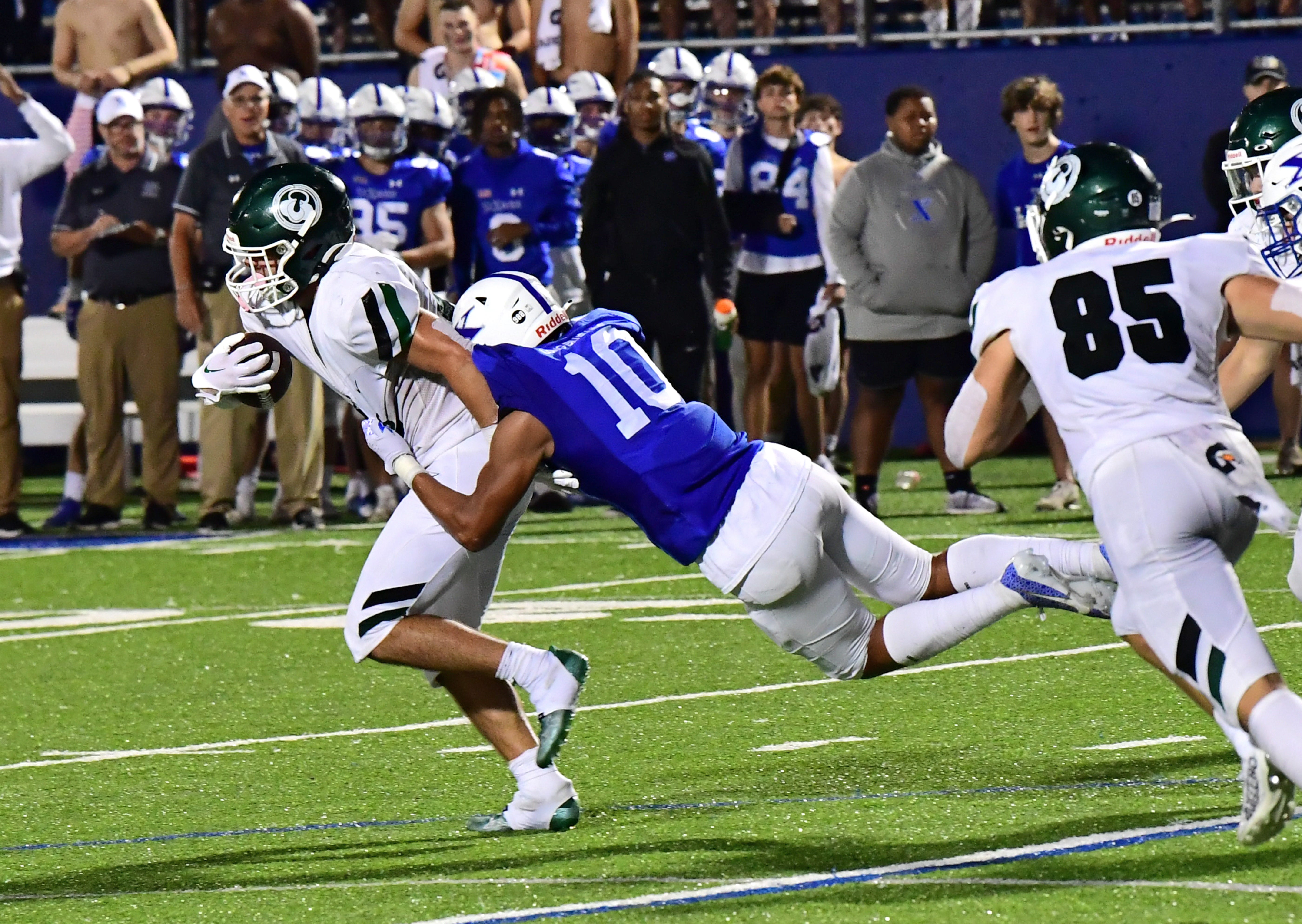 Jeremiah Lynn of Louisville Trinity carries St. Xavier's Jakobe Clapper (10) with him as he gains a first down for the Shamrocks at RDI Stadium, Sept. 29, 2023.