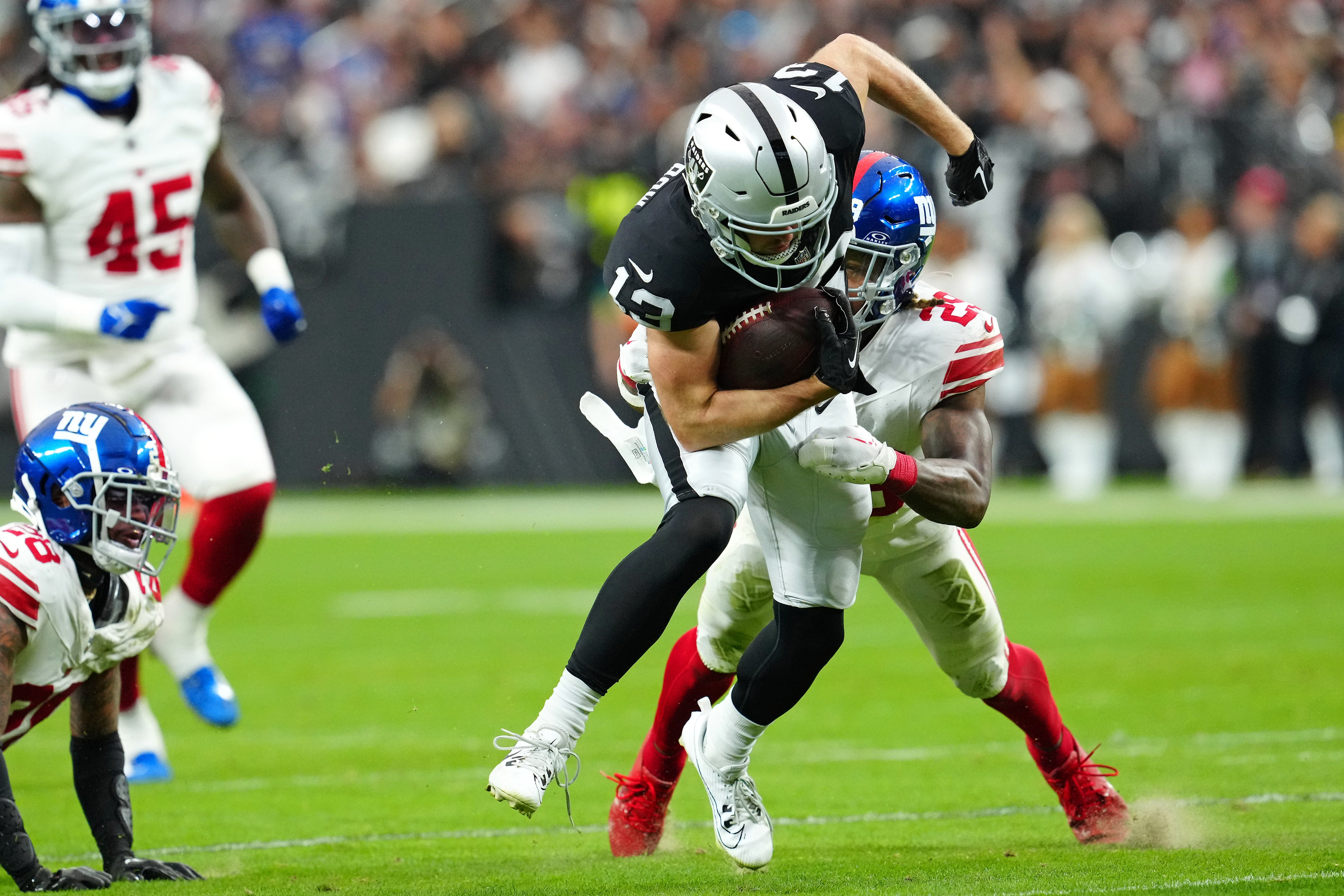 Giants safety Xavier McKinney (29) tackles Raiders wide receiver Hunter Renfrow (13)