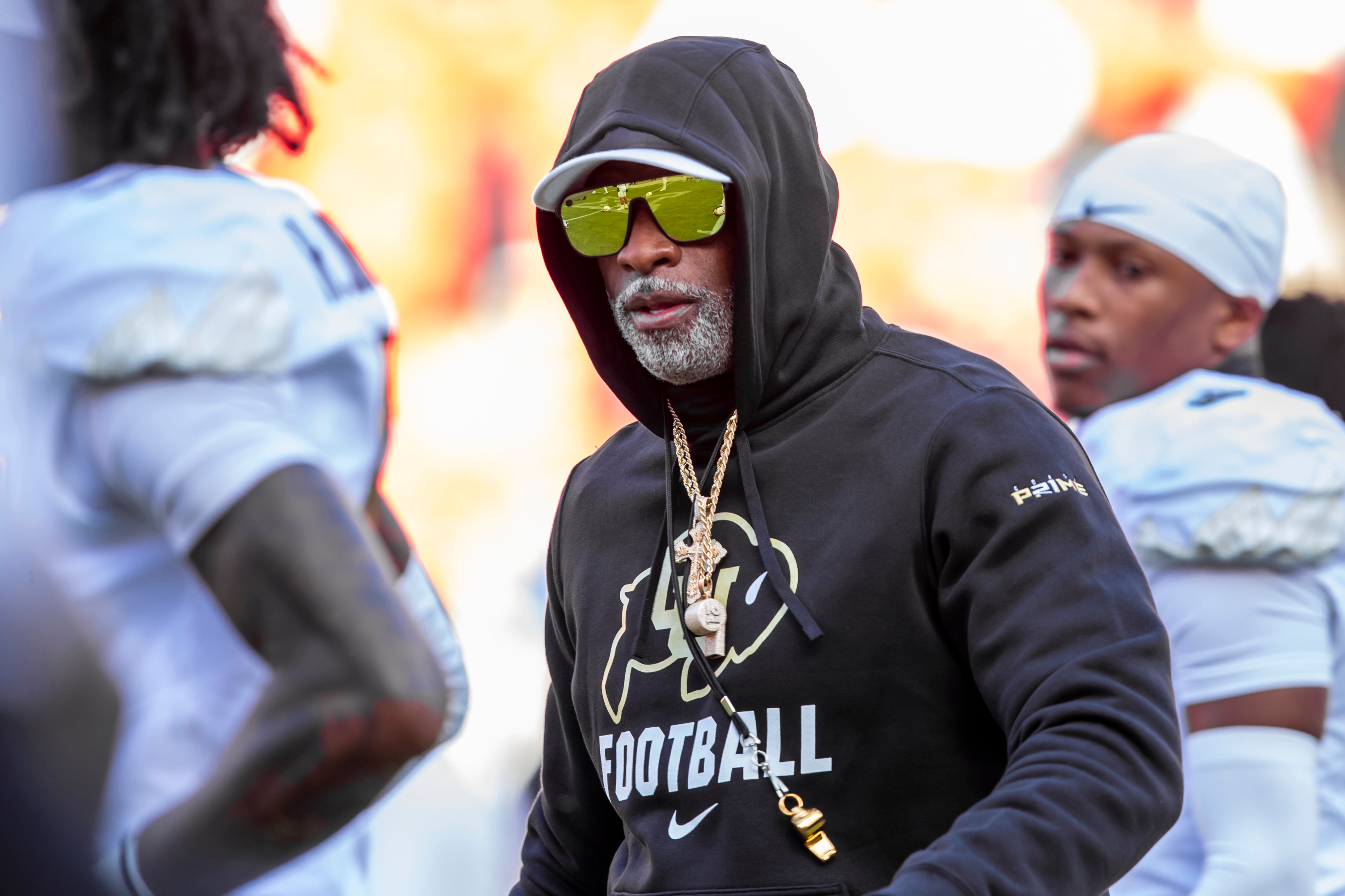 Colorado head coach Deion Sanders watches his players warmup prior to the game between the Kansas Jayhawks and the Colorado Buffaloes at GEHA Field at Arrowhead Stadium.