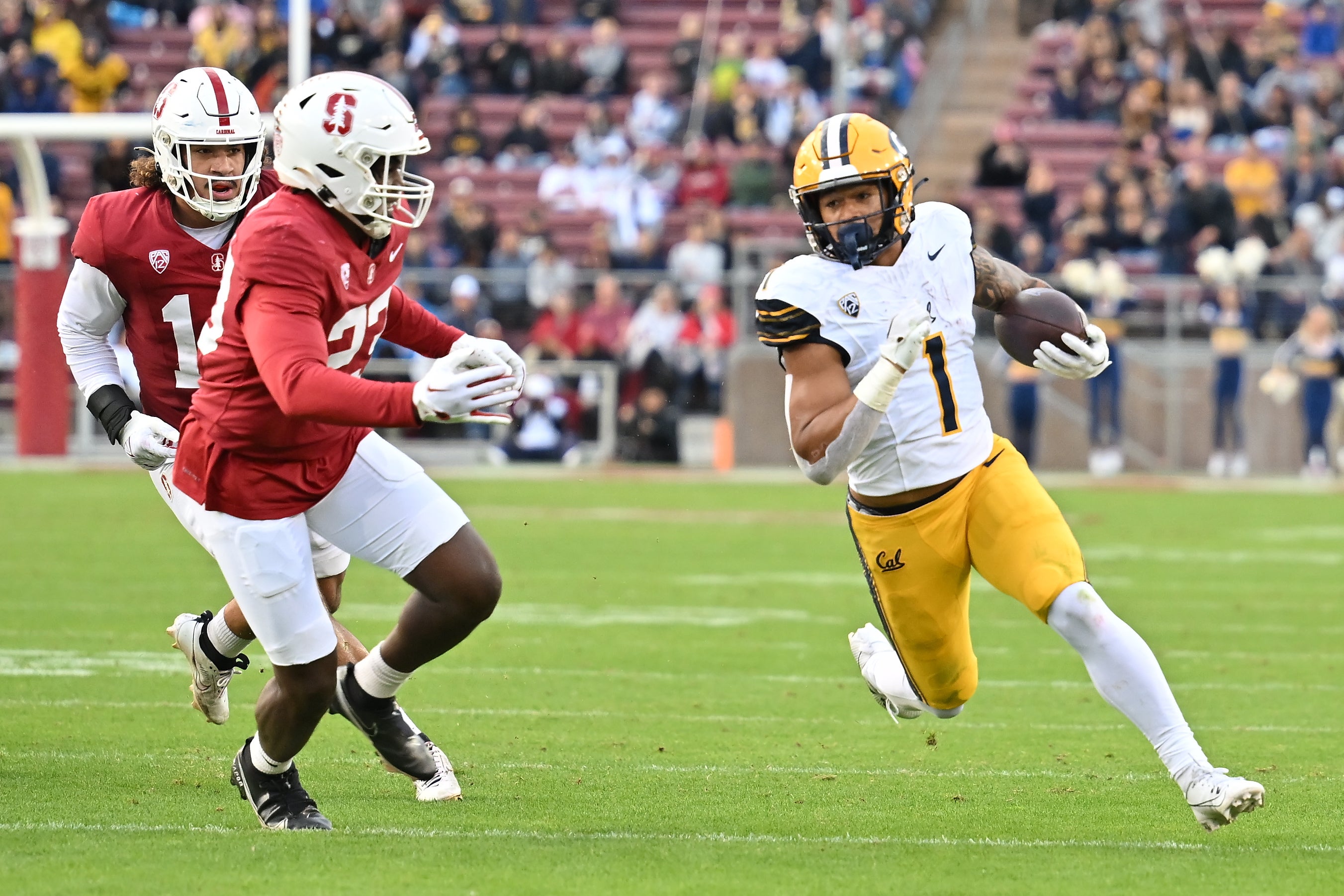 California Golden Bears running back Jaydn Ott (1) runs with the football against Stanford Cardinal linebacker David Bailey (23) during the first quarter at Stanford Stadium.
