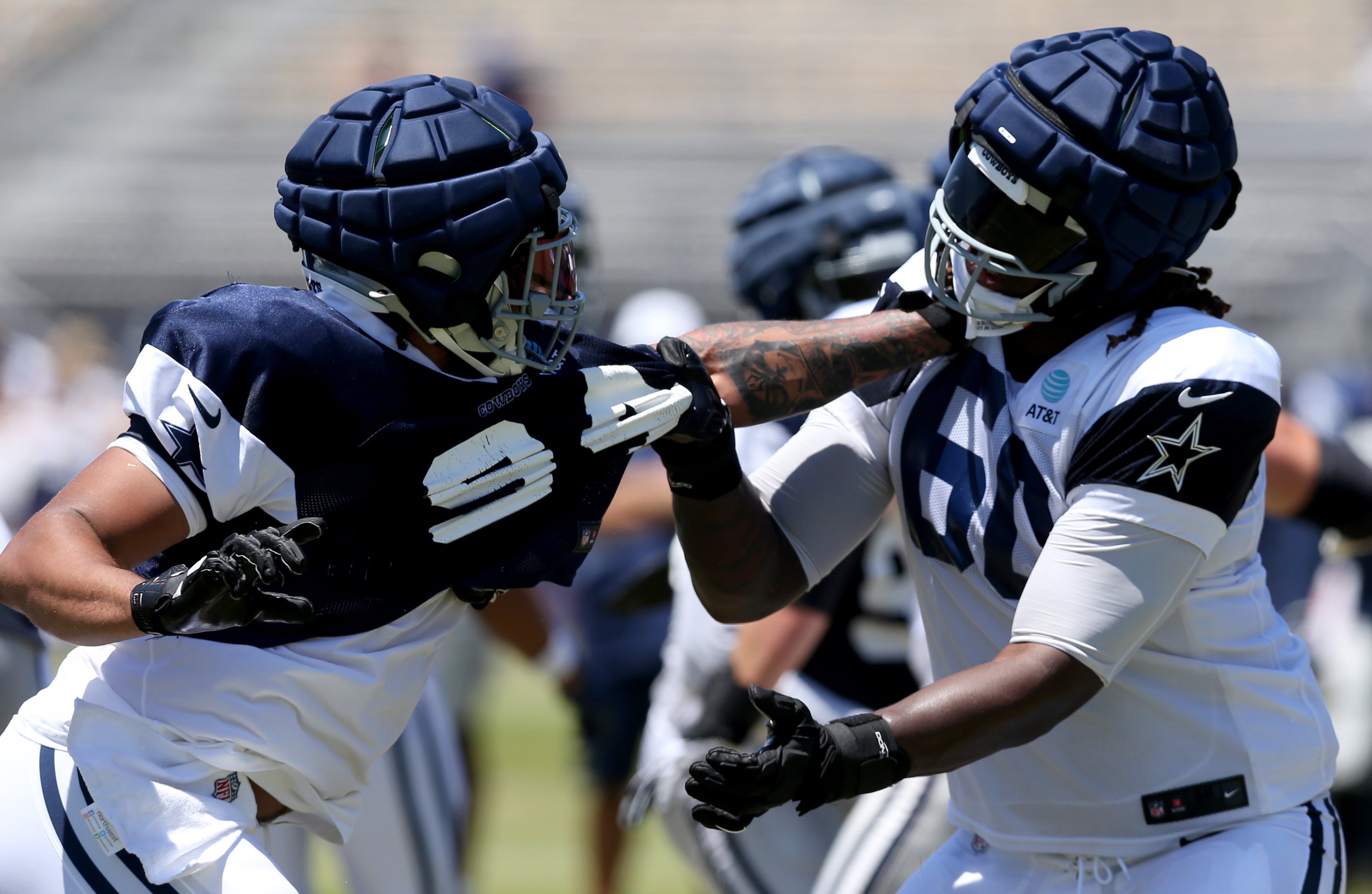 Dallas Cowboys defensive end Marshawn Kneeland (94) and offensive tackle Tyler Guyton (60) battle during training camp at the River Ridge Playing Fields in Oxnard, California.