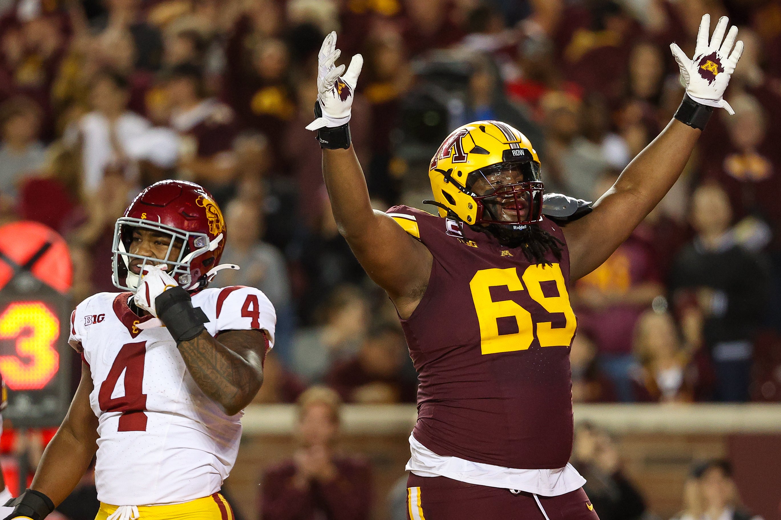 Oct 5, 2024; Minneapolis, Minnesota, USA; Minnesota Golden Gophers offensive lineman Aireontae Ersery (69) celebrates quarterback Max Brosmer's (16) touchdown against the USC Trojans during the first half at Huntington Bank Stadium. Mandatory Credit: Matt Krohn-Imagn Images