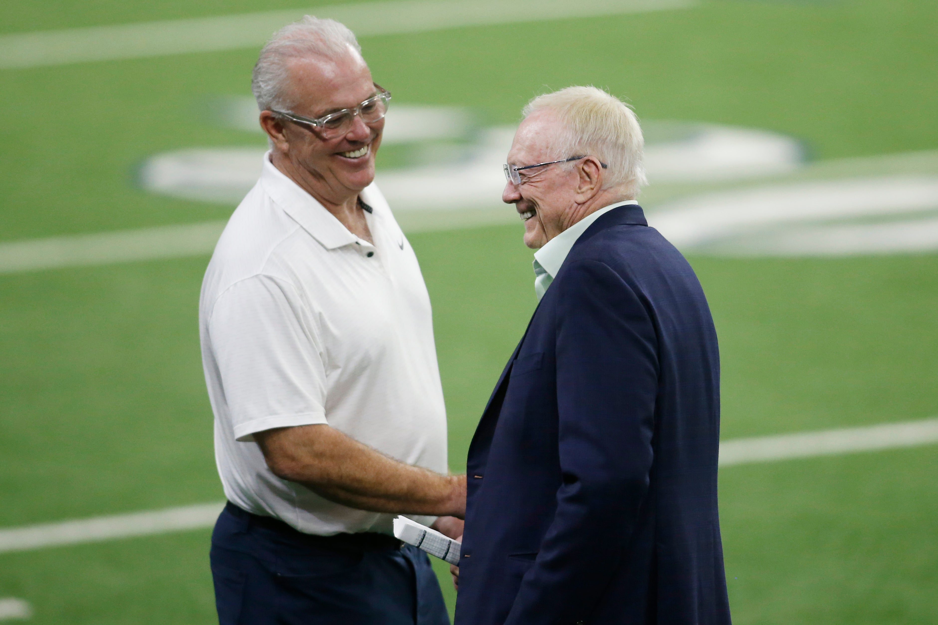 Dallas Cowboys CEO Stephen Jones (left) and owner Jerry Jones (right) talk on the field during minicamp at the Ford Center at the Star Training Facility in Frisco, Texas.