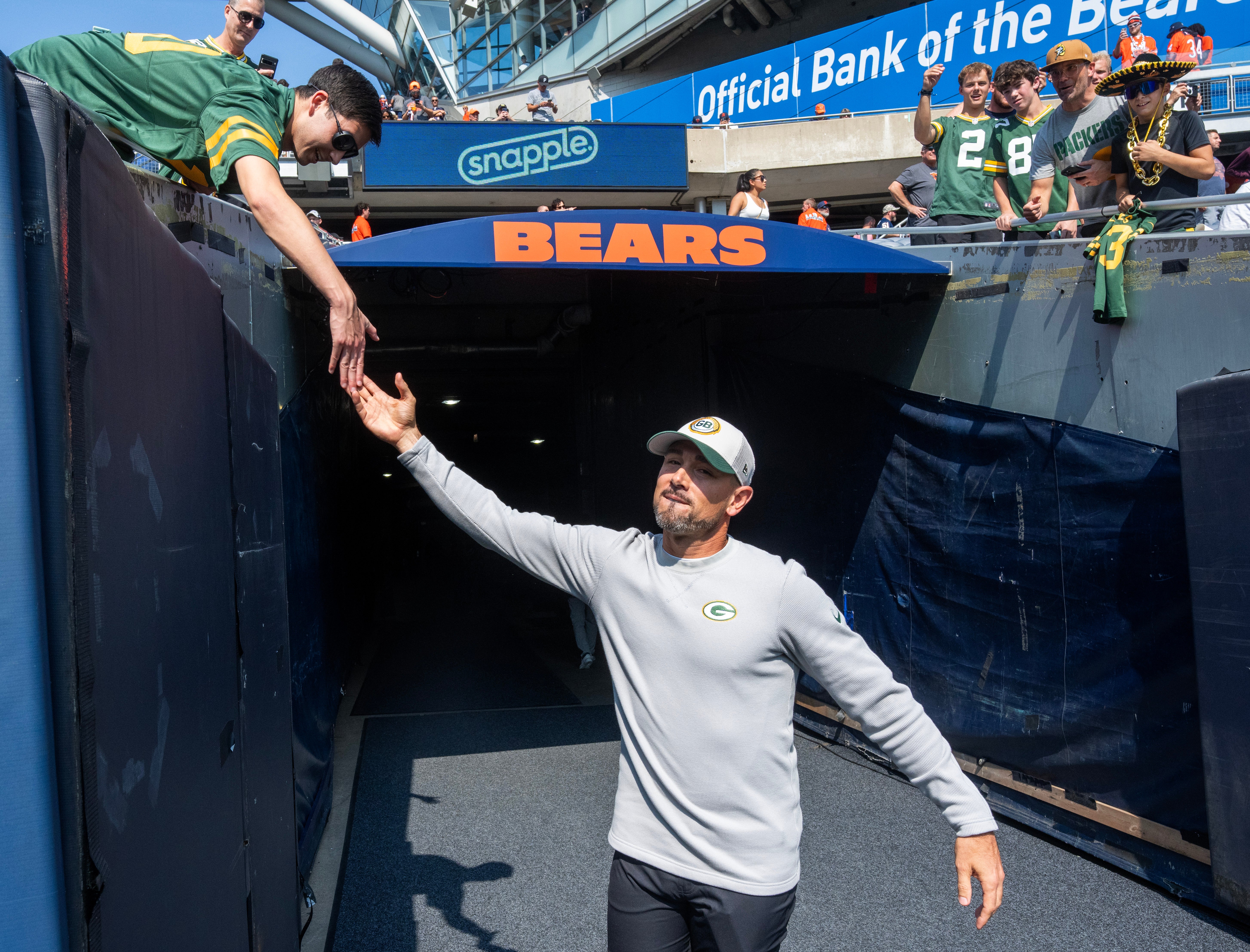 Green Bay Packers head coach Matt LaFleur greets a fan before their game against the Chicago Bears at Soldier Field.