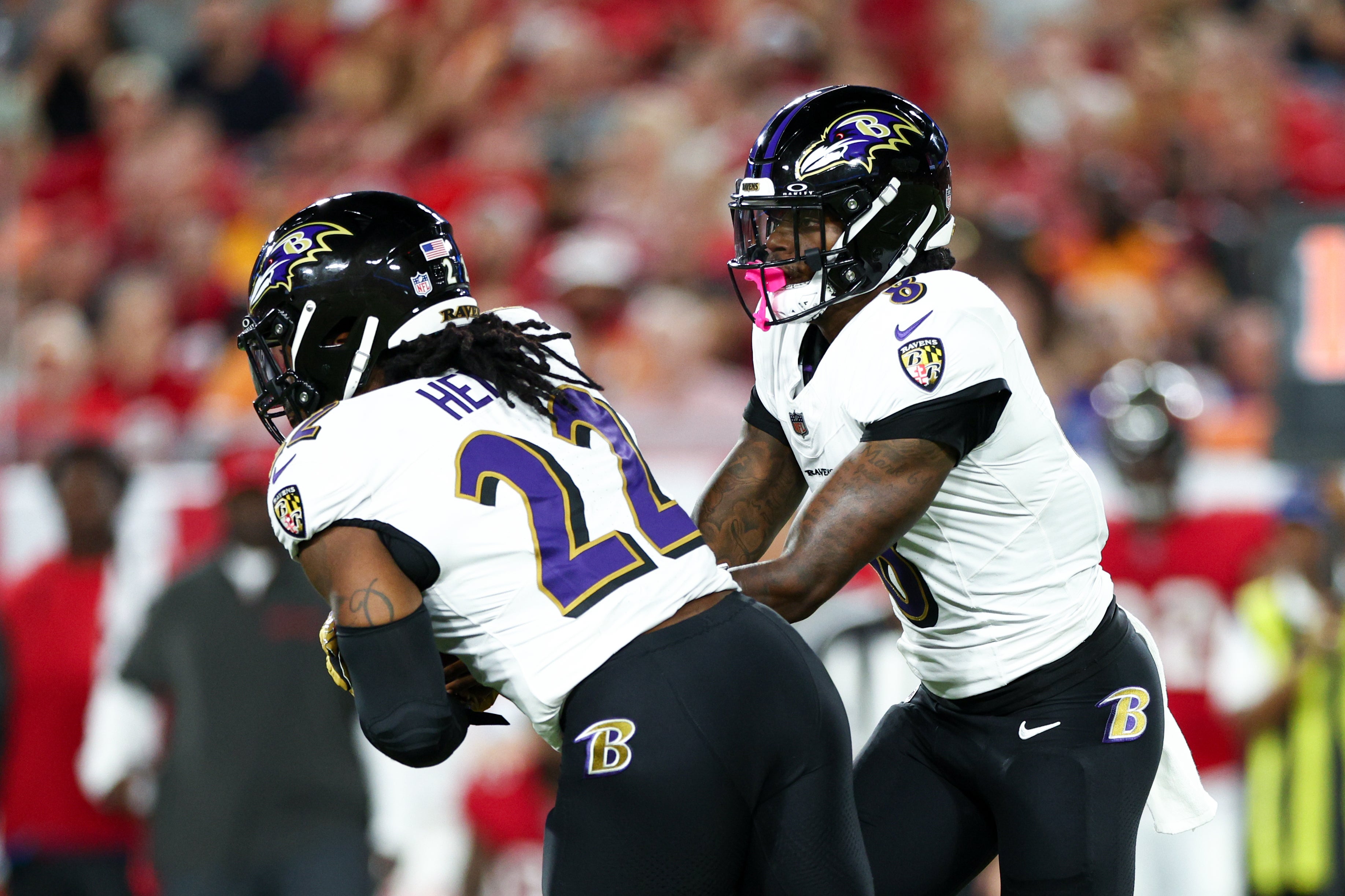 Oct 21, 2024; Tampa, Florida, USA; Baltimore Ravens quarterback Lamar Jackson (8) hands off to running back Derrick Henry (22) against the Tampa Bay Buccaneers in the first quarter at Raymond James Stadium.