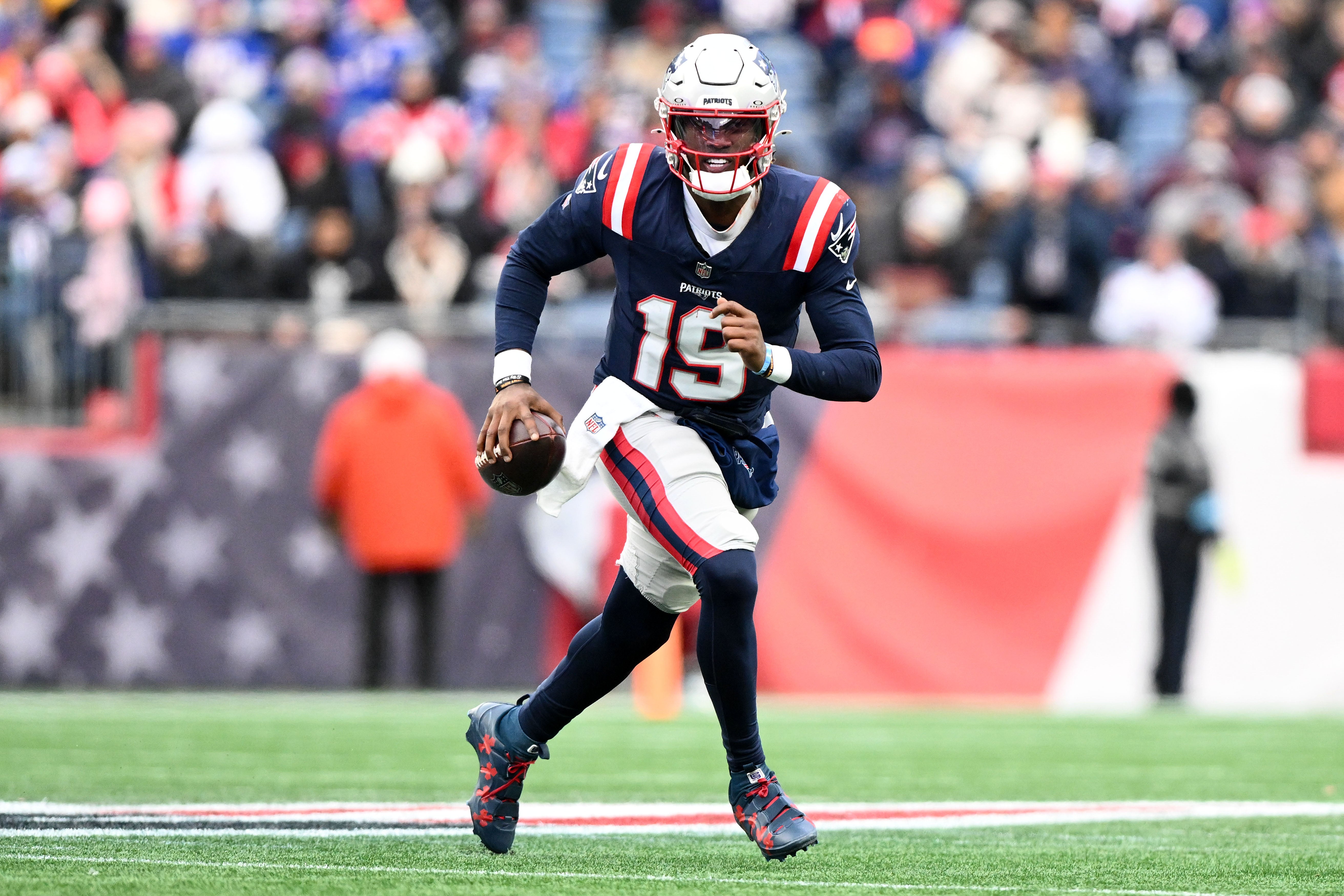 Jan 5, 2025; Foxborough, Massachusetts, USA; New England Patriots quarterback Joe Milton III (19) runs against the Buffalo Bills during the first half at Gillette Stadium.