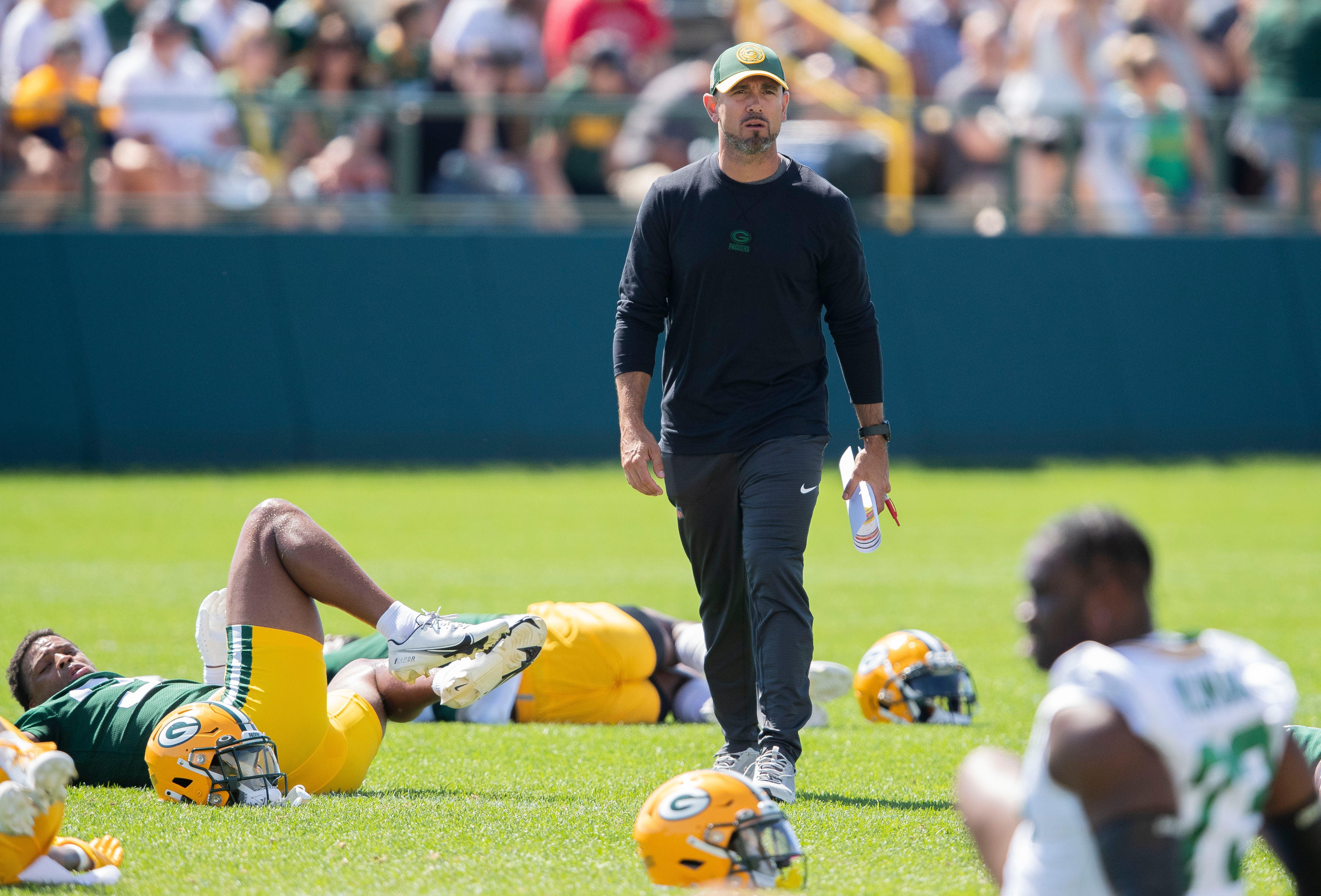 Green Bay Packers head coach Matt LaFleur surveys the field while the team stretches during practice at Ray Nitschke Field.