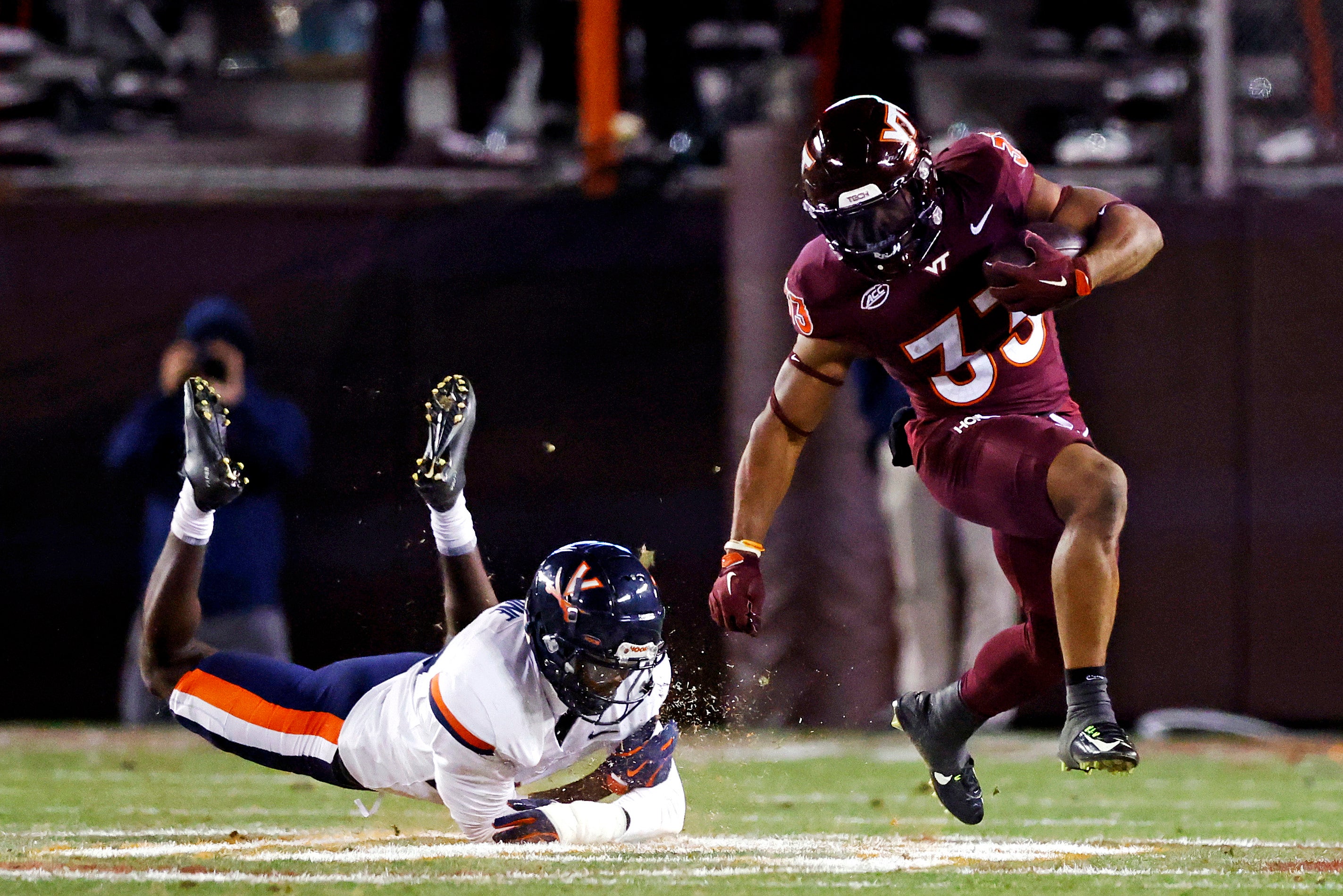 Nov 30, 2024; Blacksburg, Virginia, USA; Virginia Tech Hokies running back Bhayshul Tuten (33) runs the ball against Virginia Cavaliers defensive end Miles Greene (14) during the fourth quarter at Lane Stadium.