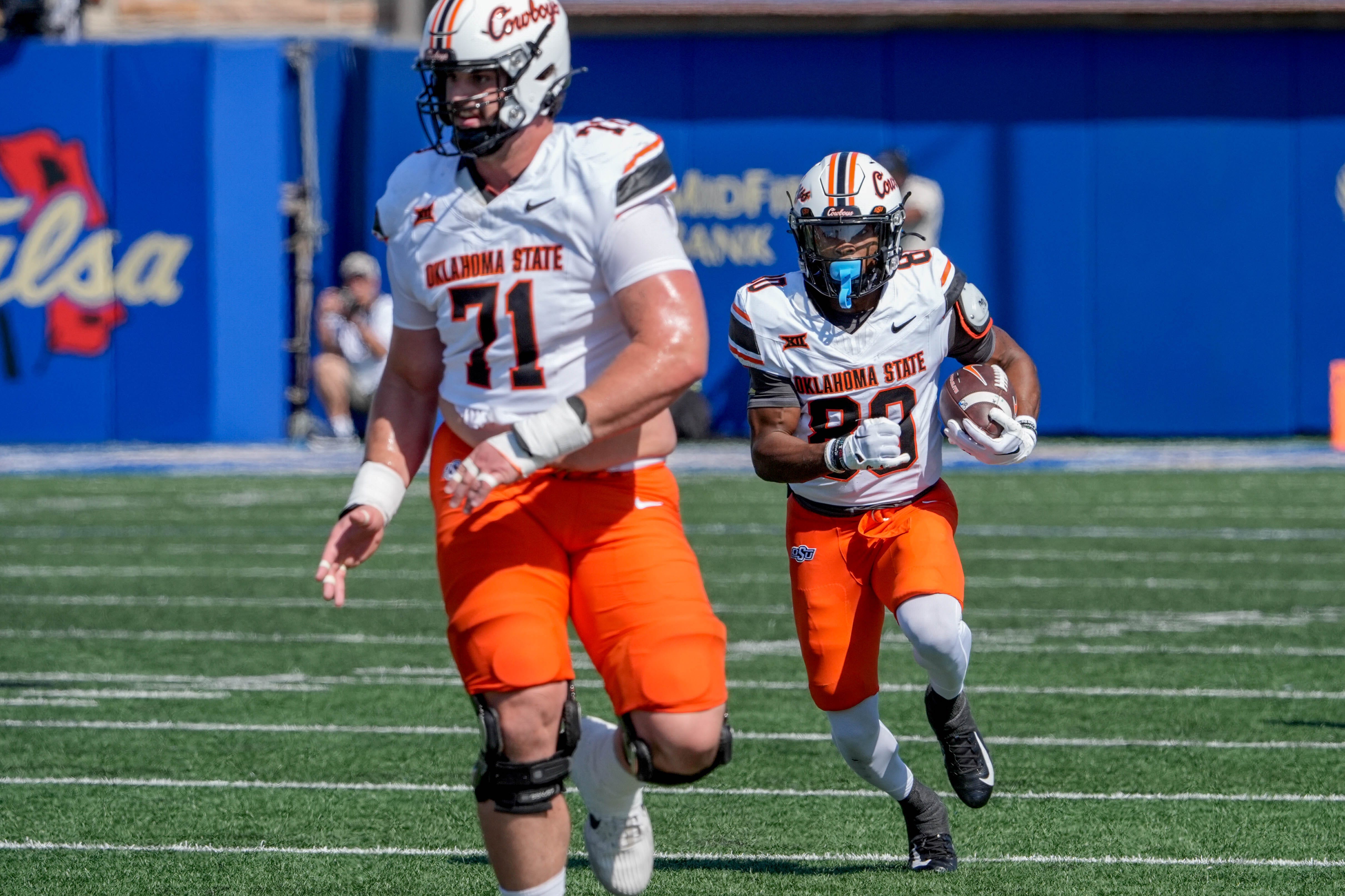Oklahoma State running back Rodney Fields Jr. (20) runs the ball behind offensive lineman Dalton Cooper (71)