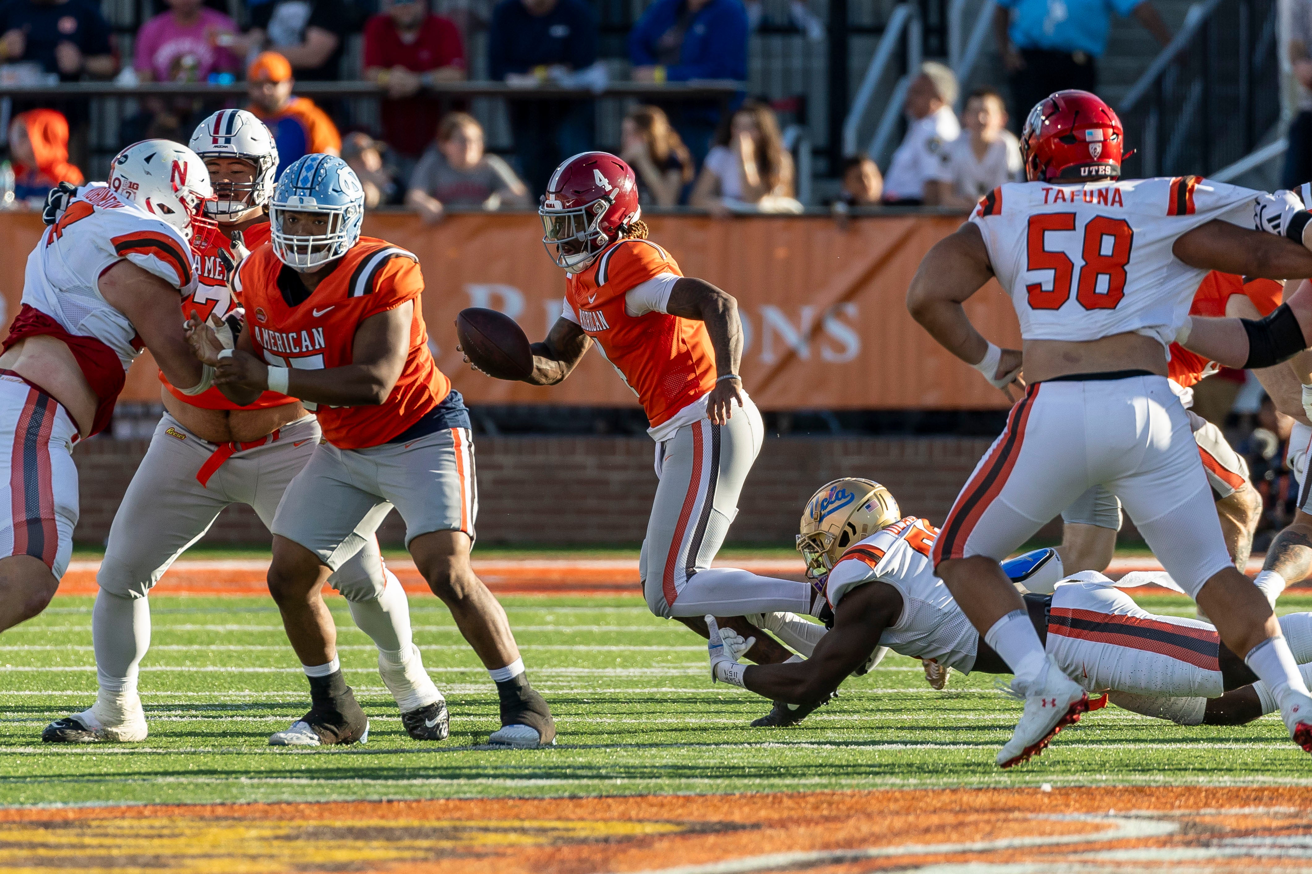 Feb 1, 2025; Mobile, AL, USA; American team quarterback Jalen Milroe of Alabama (4) runs from National team defensive lineman Oluwafemi Oladejo of UCLA (99) during the second half of the 2025 Senior Bowl at Hancock Whitney Stadium. Mandatory Credit: Vasha Hunt-Imagn Images